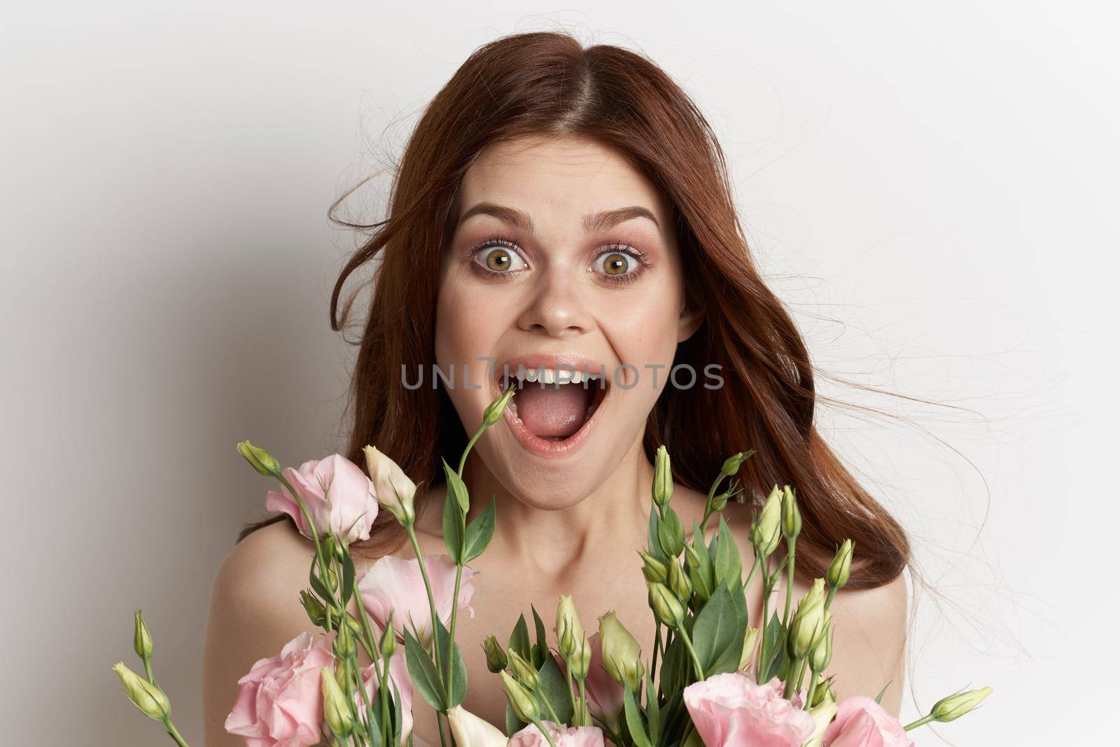 attractive woman in dress posing flowers makeup light background. High quality photo