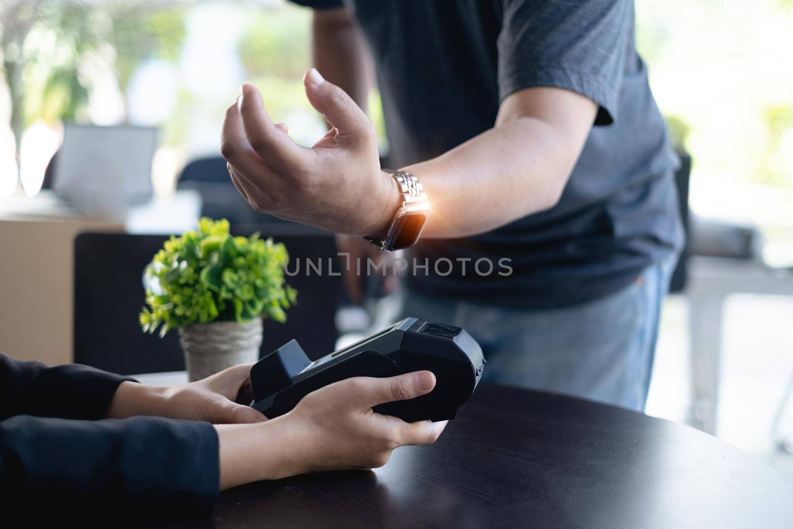 Modern man paying insurance or house bill by smartwatch. Accepting payment over nfc technology
