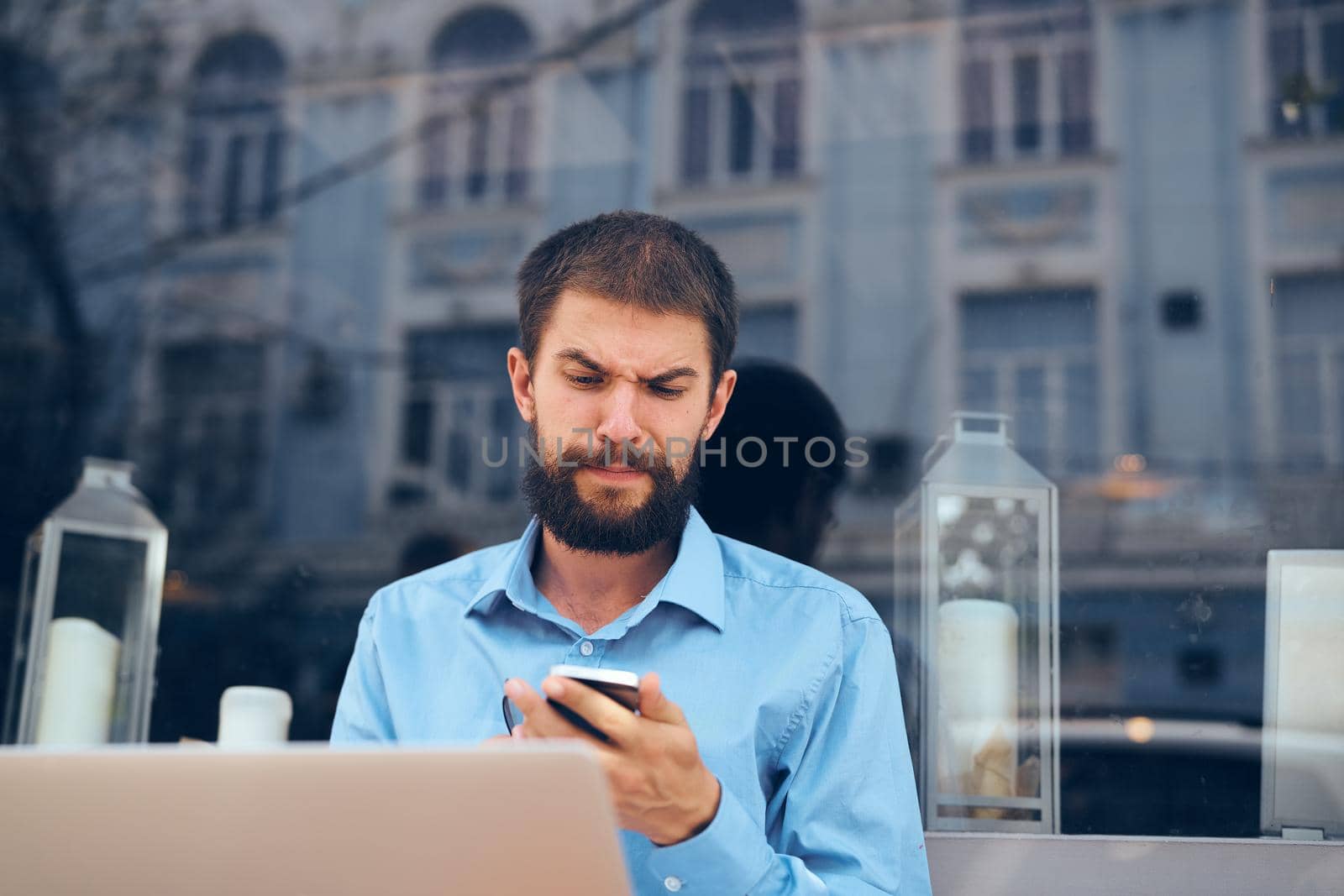 a man in a blue shirt on the street with a laptop manager. High quality photo
