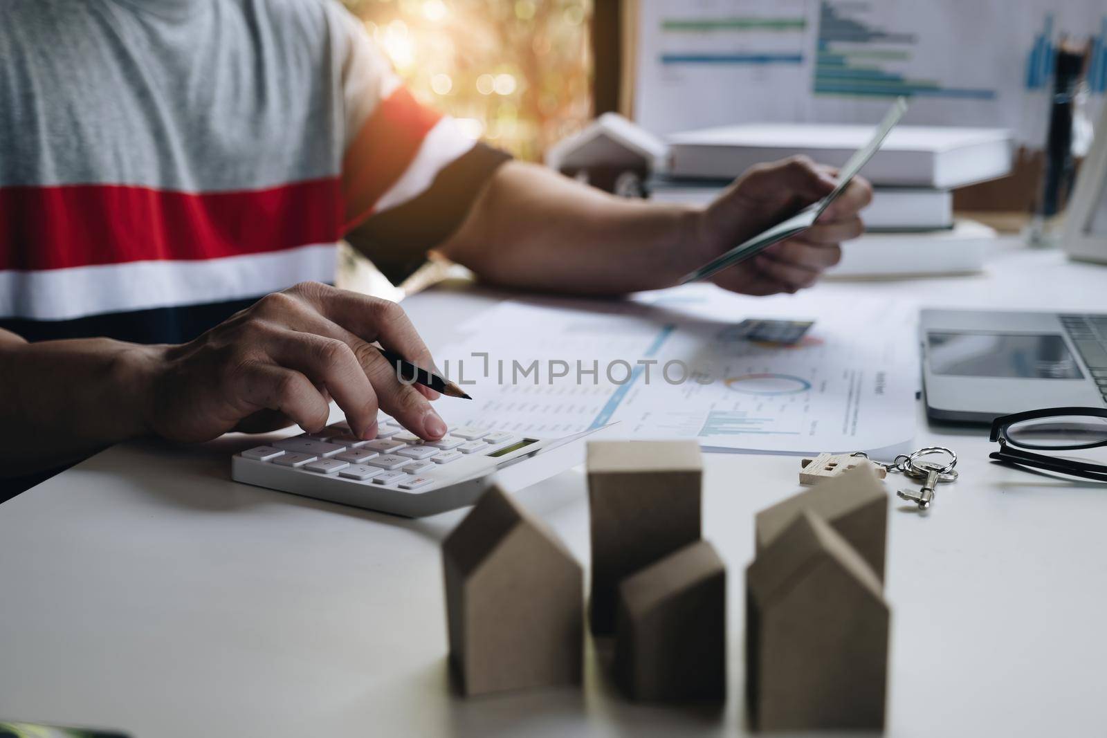 Businessman holding bank savings account and calculating house bill, account or saving money or insurance concept. by itchaznong