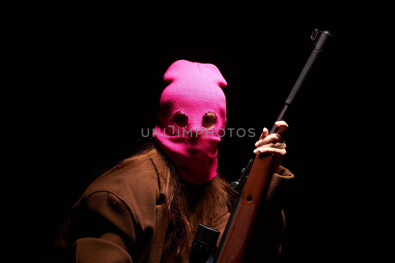 woman in glamorous pink mask shotgun posing black background. High quality photo