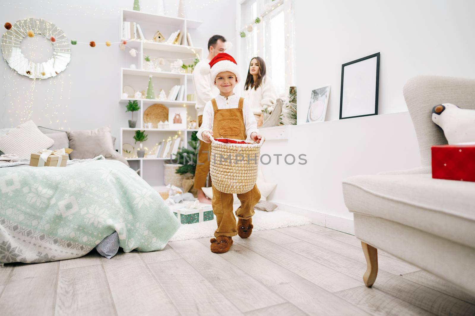 Parent and their little son having fun and playing together indoors at Christmas time at home