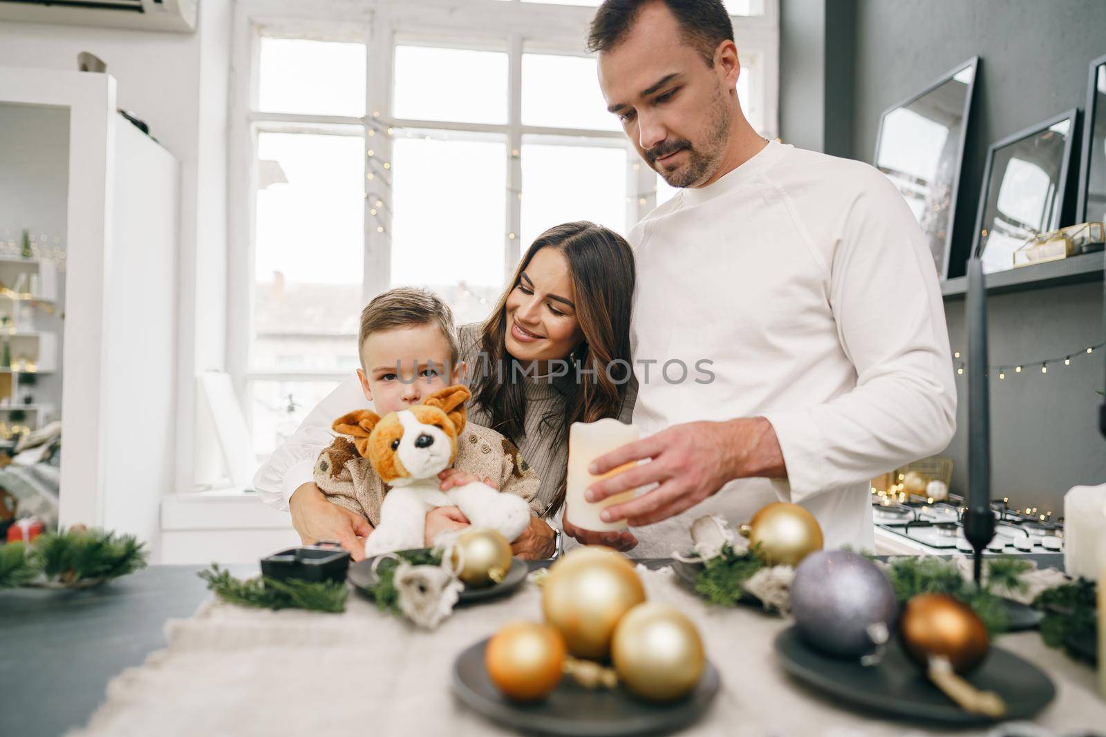 A portrait of happy family in the kitchen decorated for Christmas holidays