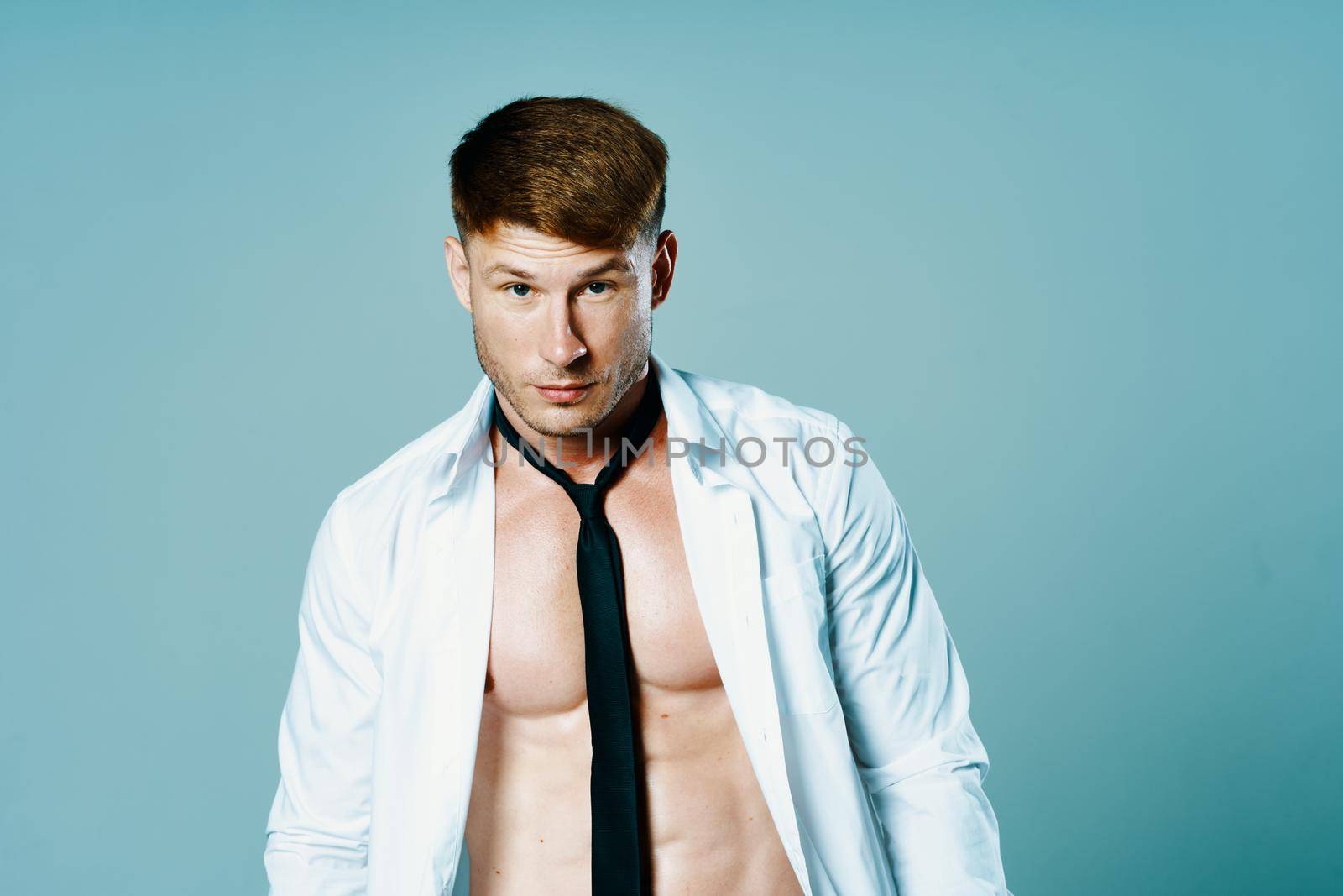 sporty man in unbuttoned shirt with muscle tie posing. High quality photo
