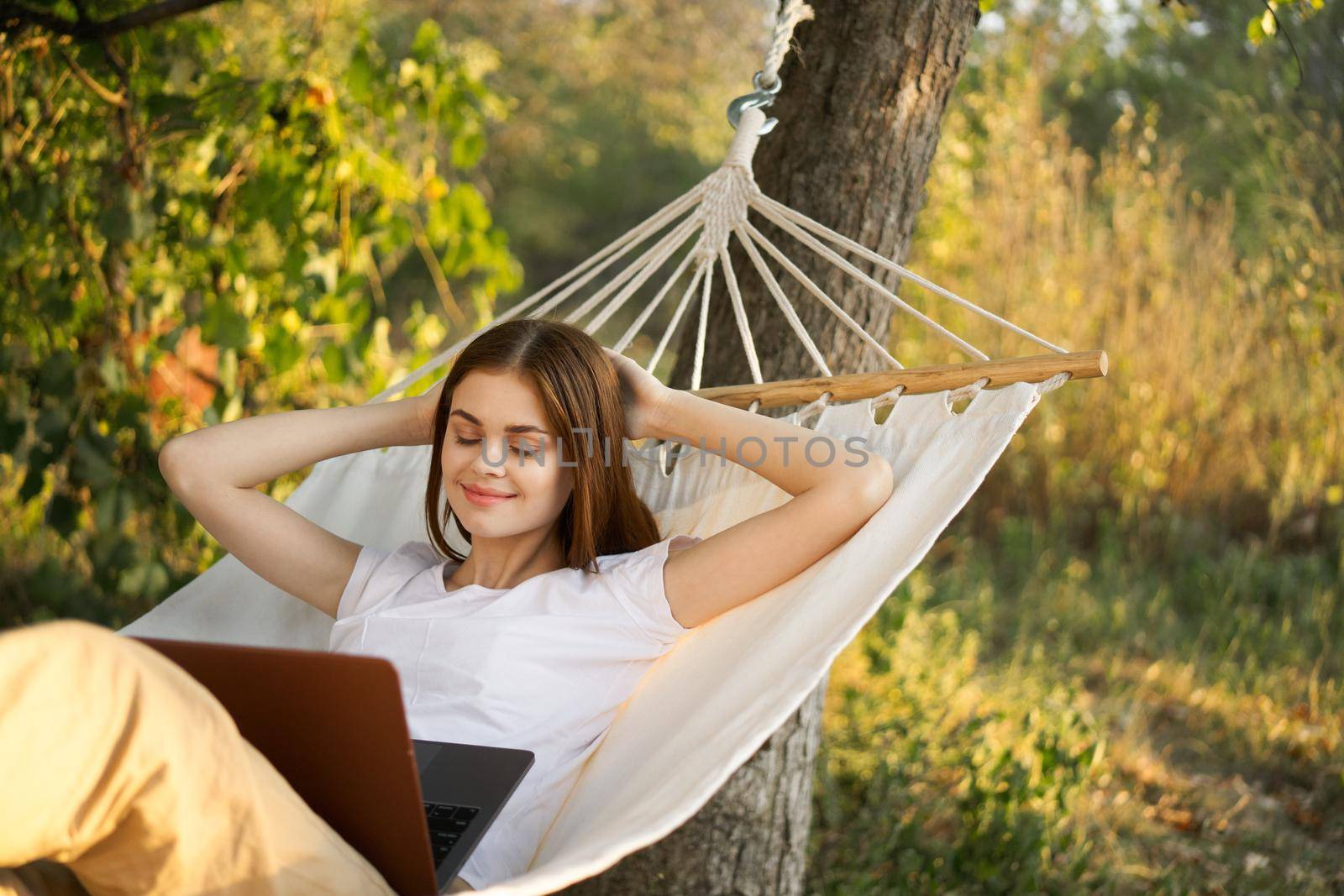 women outdoors lies in a hammock with a laptop freelance internet. High quality photo