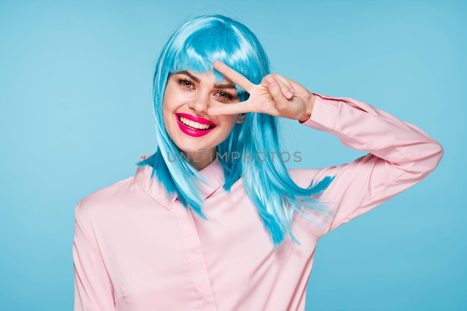 cheerful glamorous woman in pink shirt blue wig makeup model. High quality photo