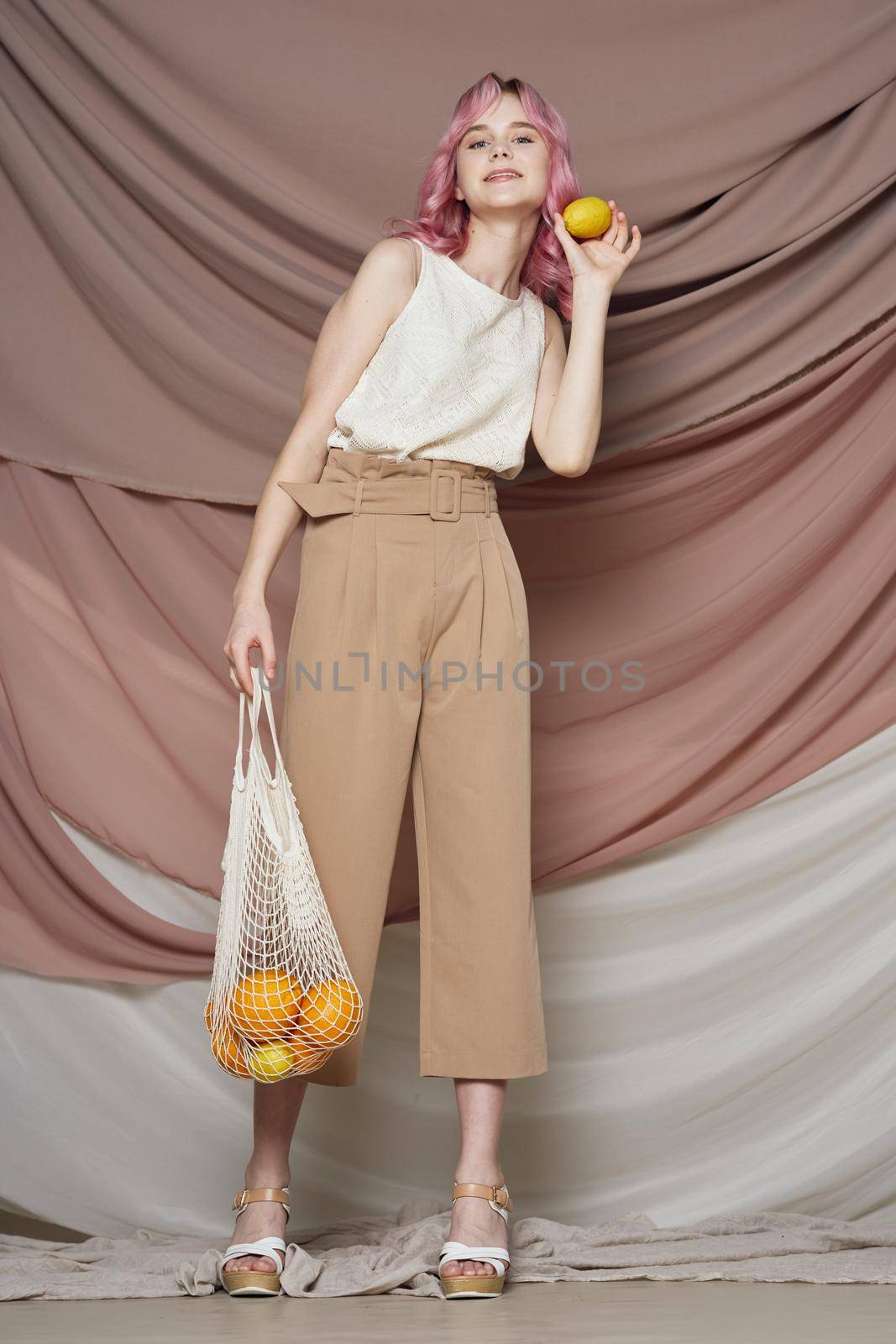 woman with pink hair pack with oranges posing fashion. High quality photo