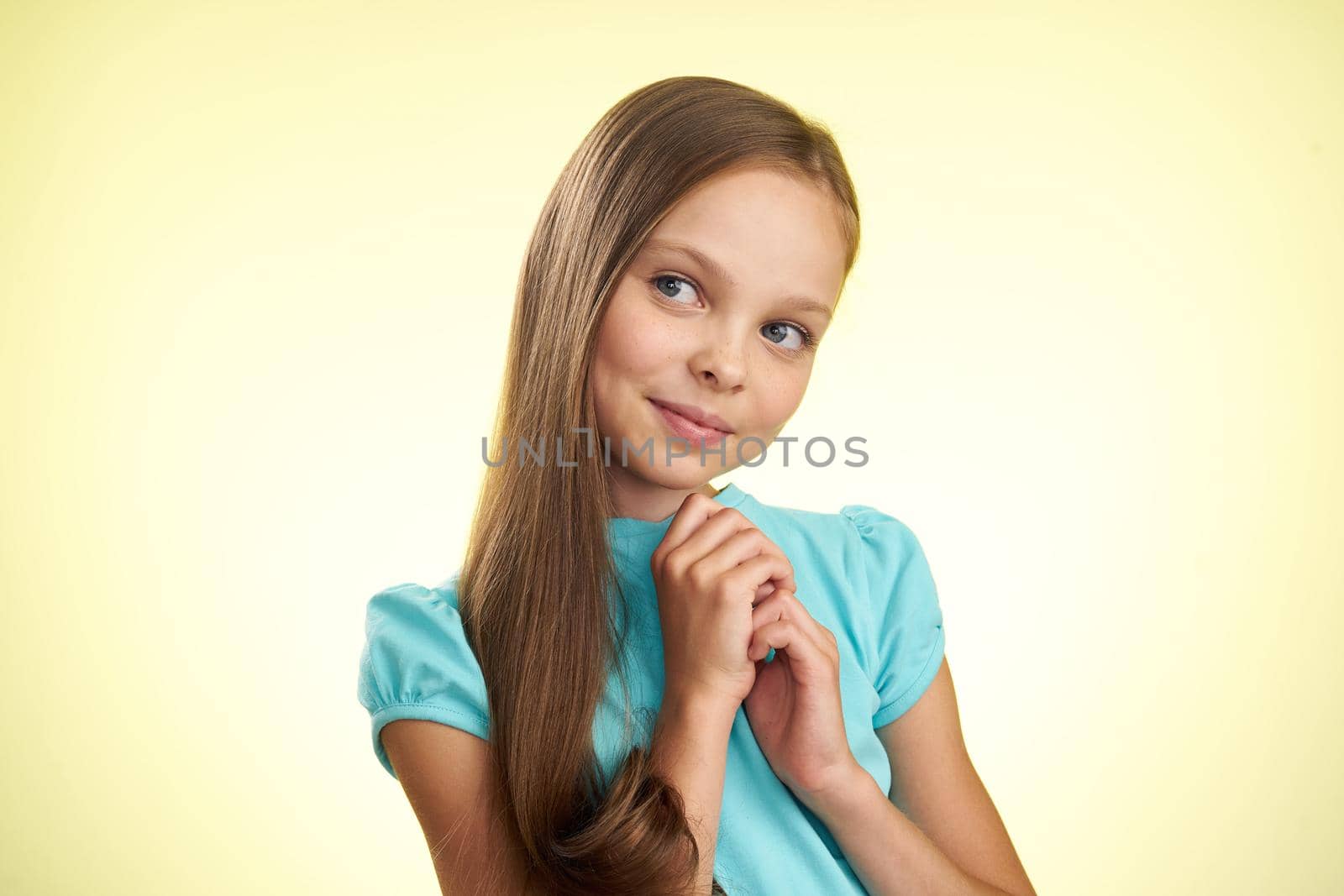 cheerful little girl with long hair close-up studio posing. High quality photo