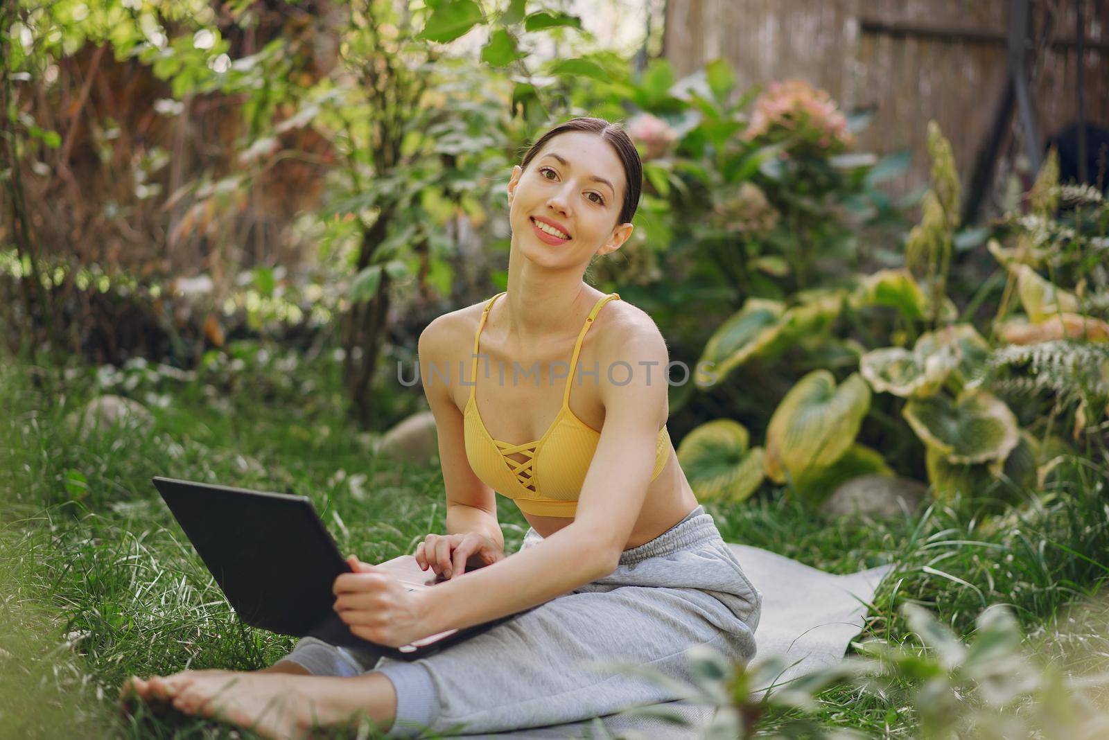 Girl in a summer park. Woman in a yellow top. Lady with a laptop.