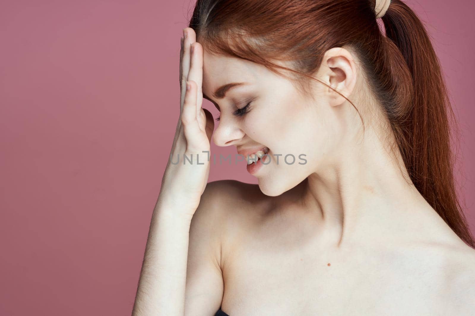 woman with bare shoulders charm cosmetics pink background posing. High quality photo