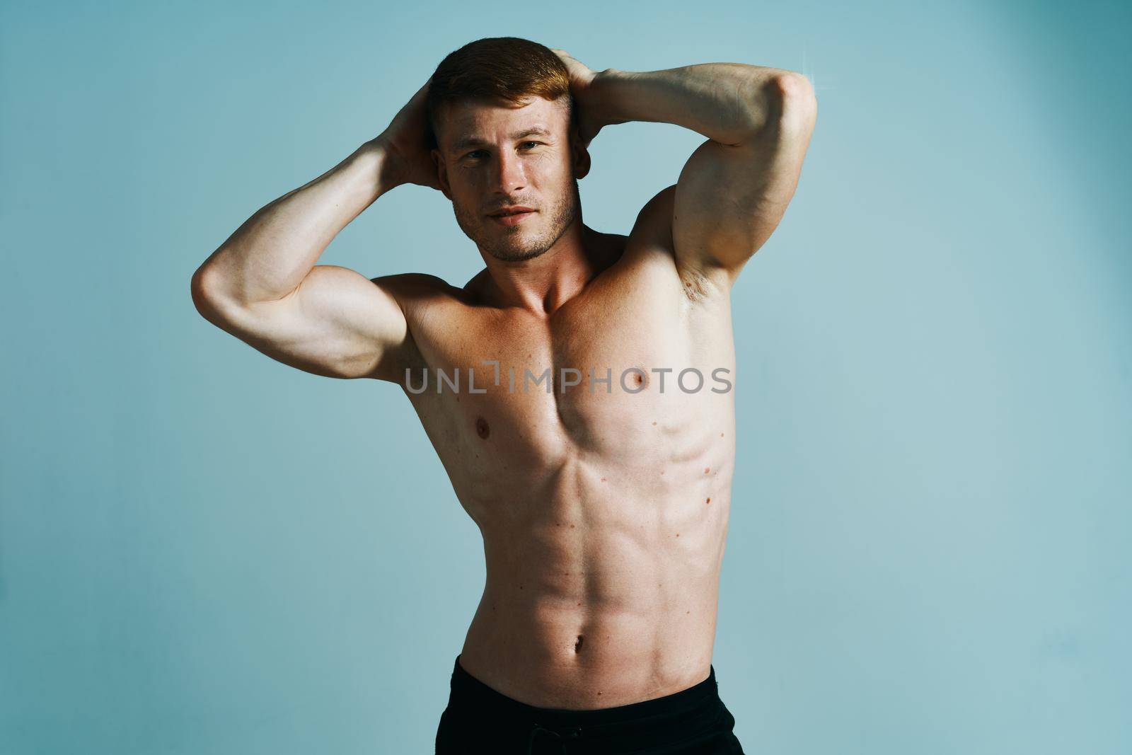 bodybuilder with muscular body posing press blue background. High quality photo