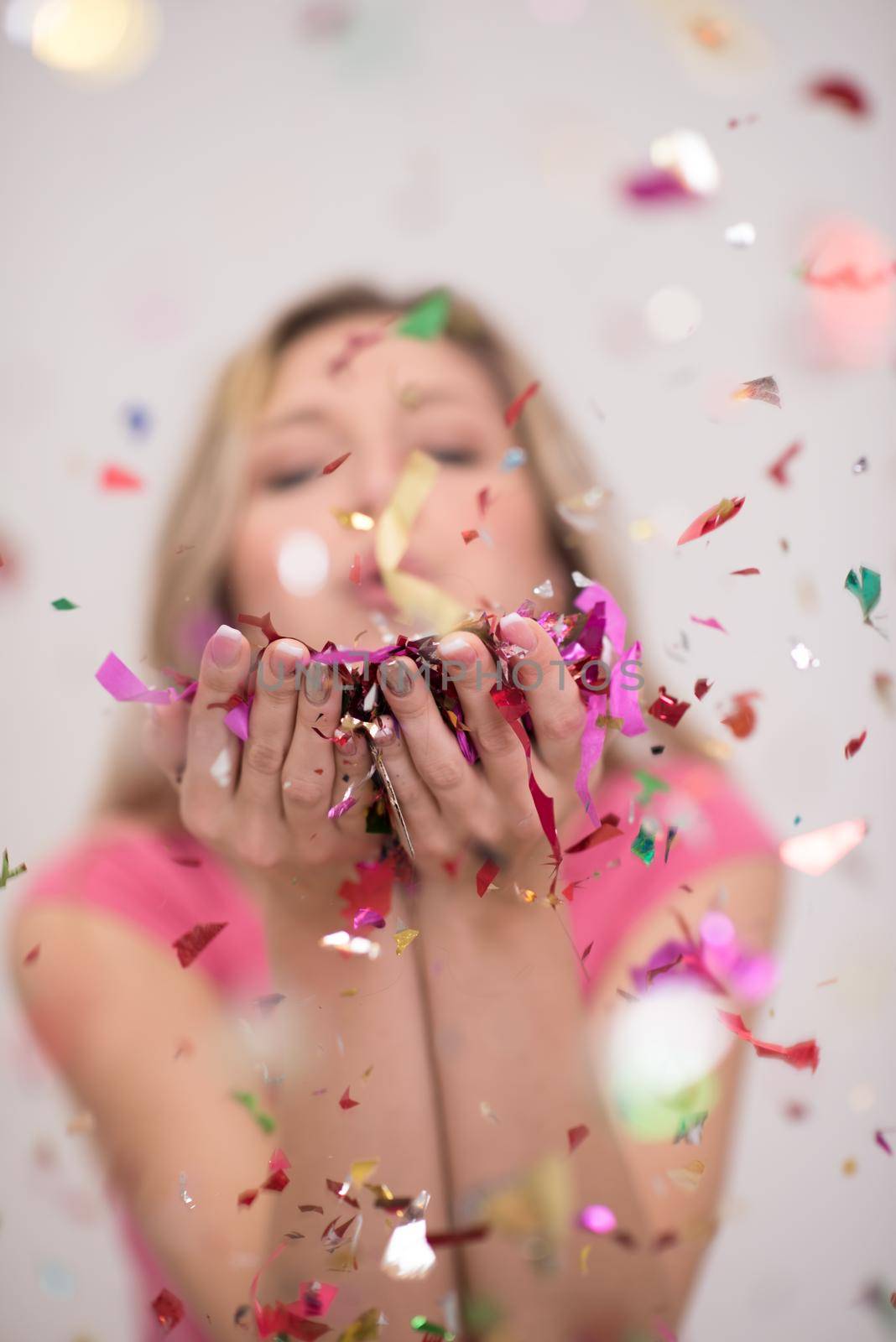 woman blowing confetti in the air by dotshock