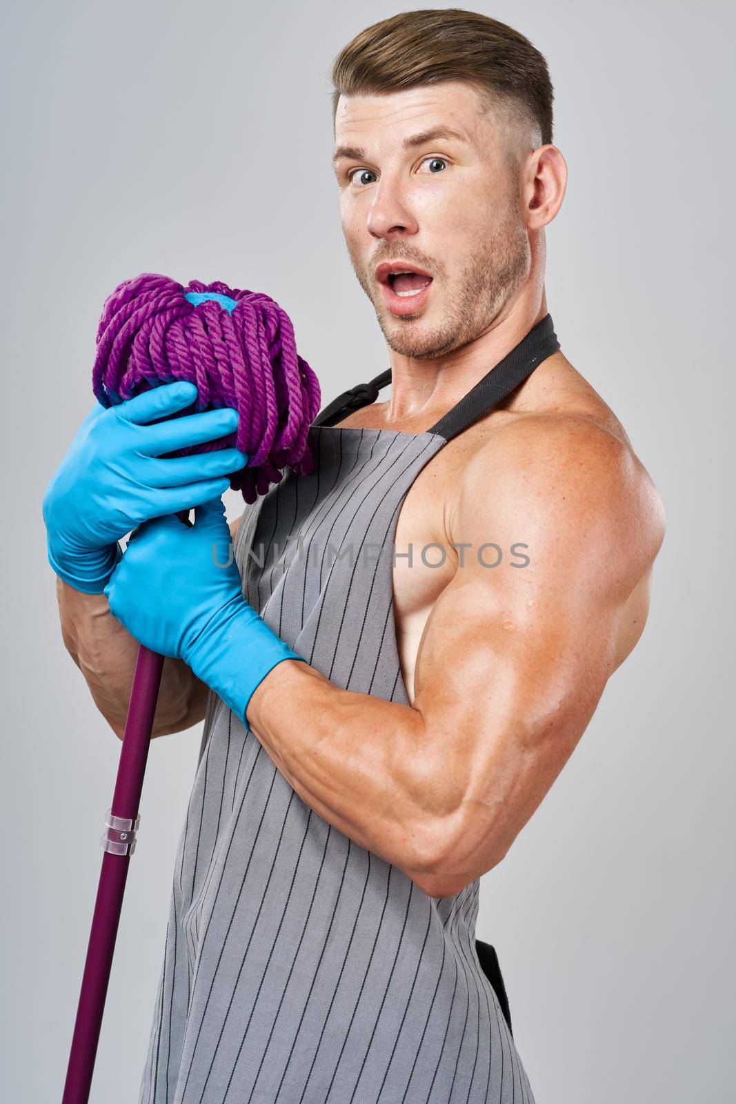 man in apron with mop in hand posing housework by Vichizh