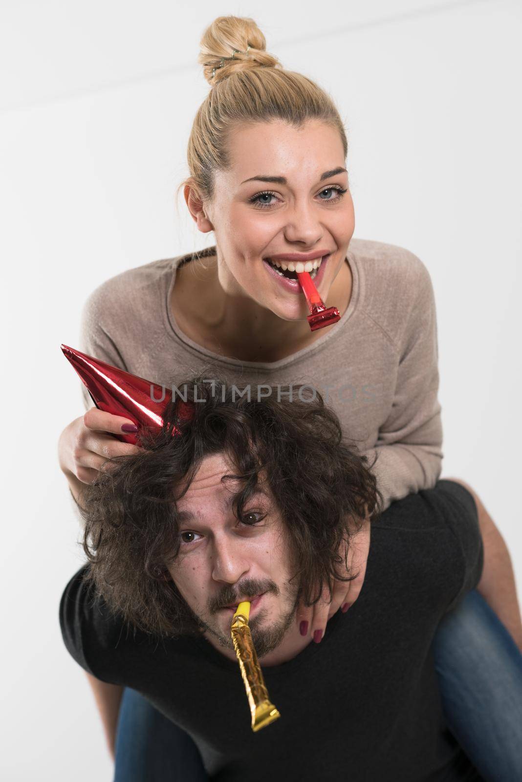 happy young romantic  couple in love  celebrating and blowing confetti decorations at new year and charismas  party