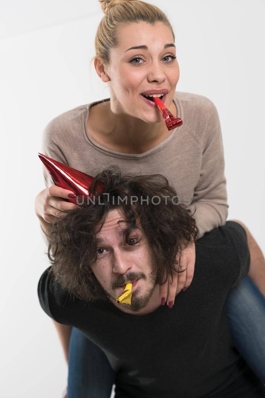 happy young romantic  couple in love  celebrating and blowing confetti decorations at new year and charismas  party