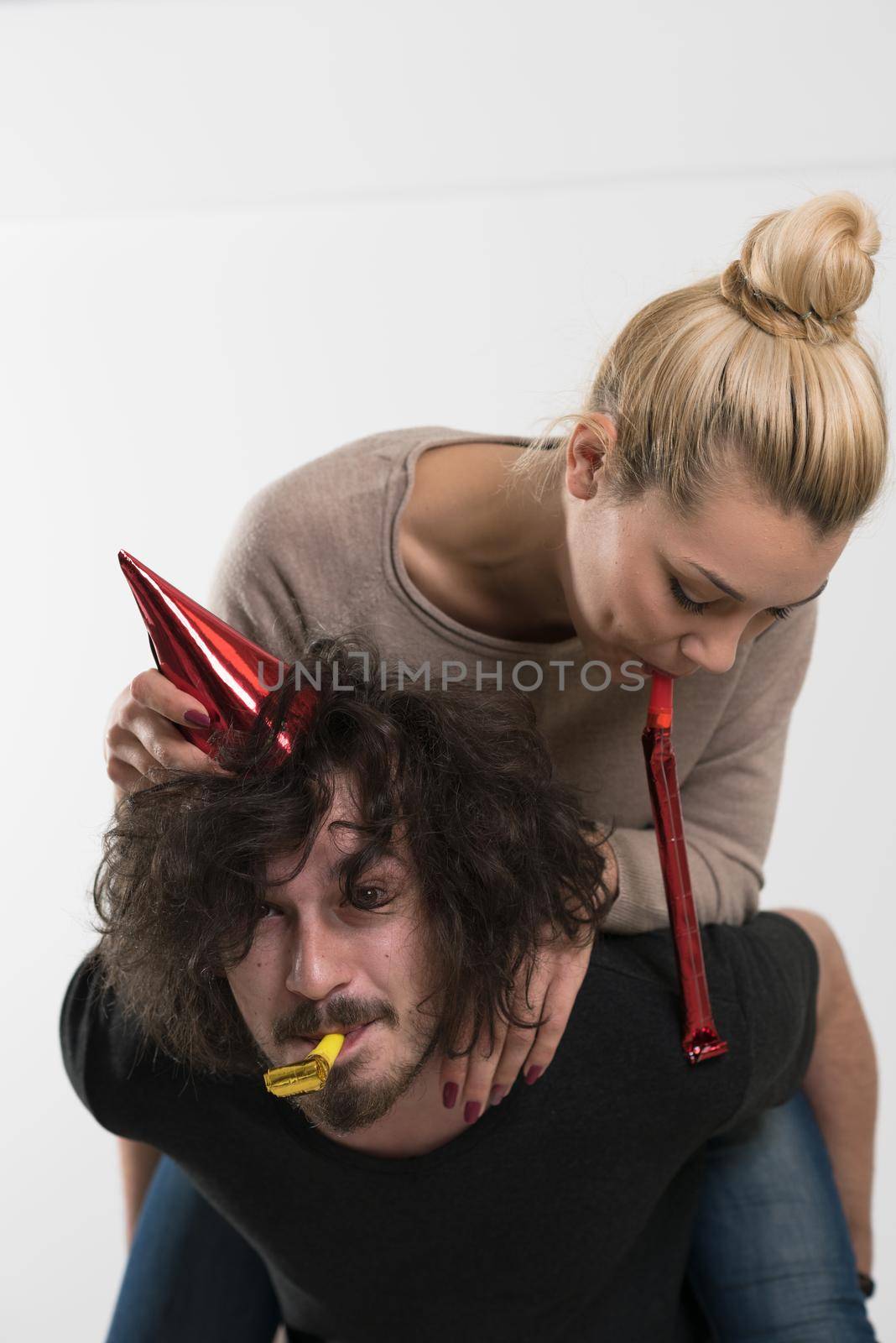 happy young romantic  couple in love  celebrating and blowing confetti decorations at new year and charismas  party