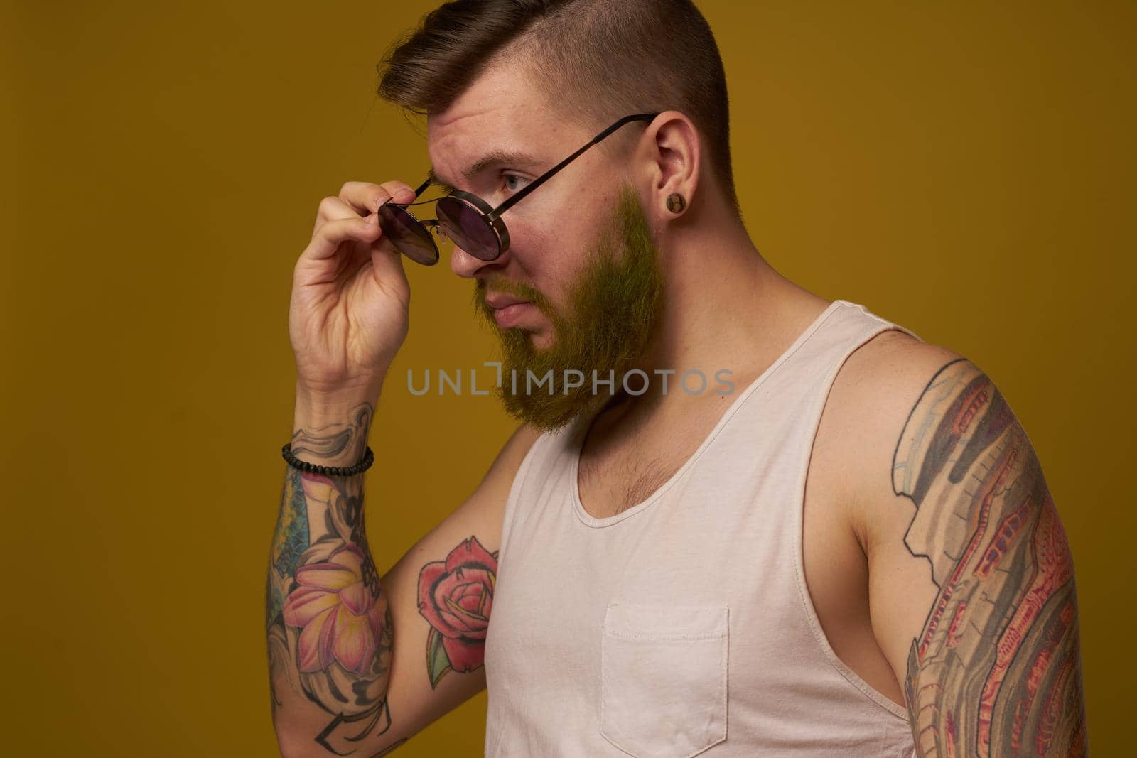 man in a white t-shirt tattoos on his arms fashion glasses modern style. High quality photo