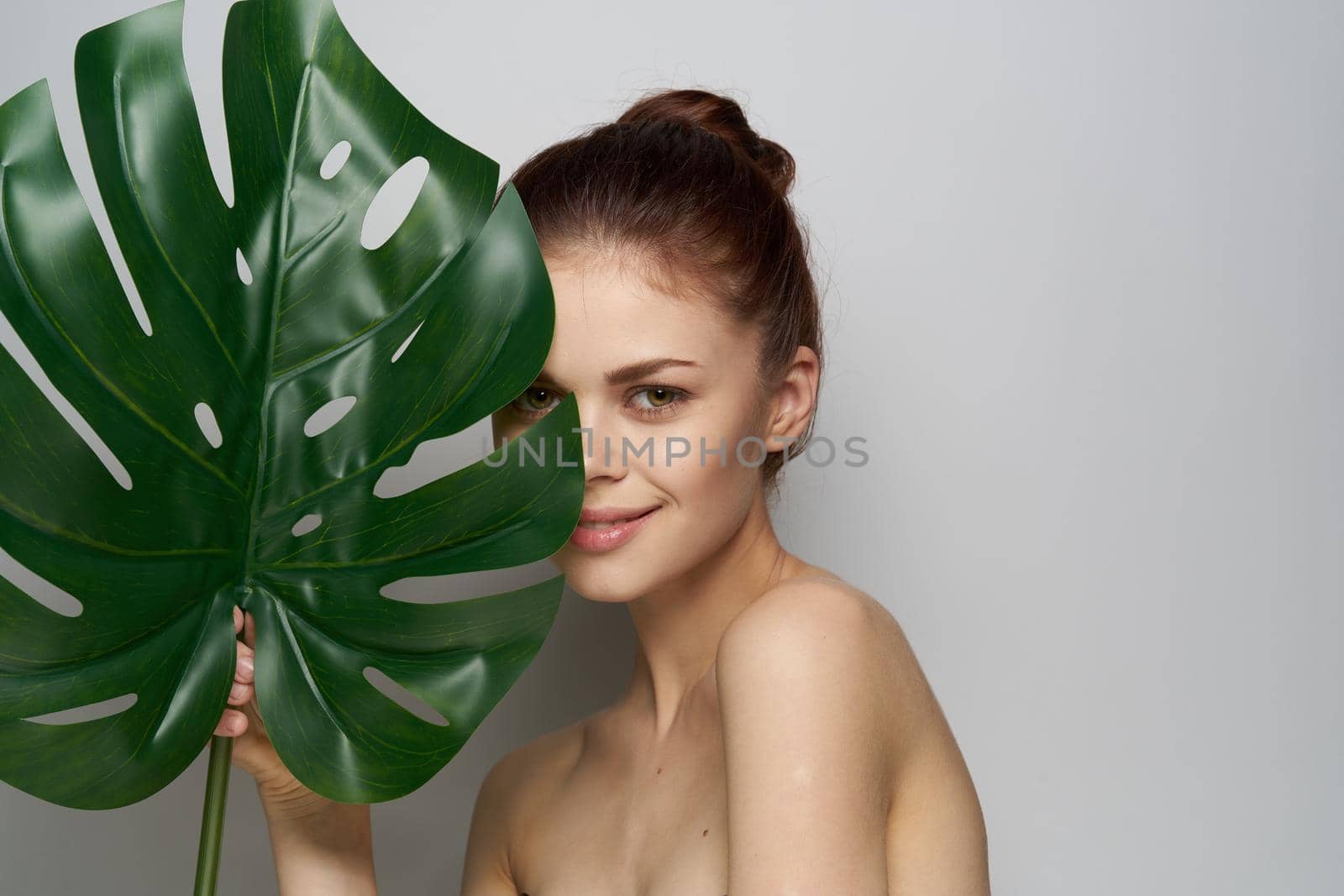 attractive woman palm leaf bare shoulders studio model. High quality photo
