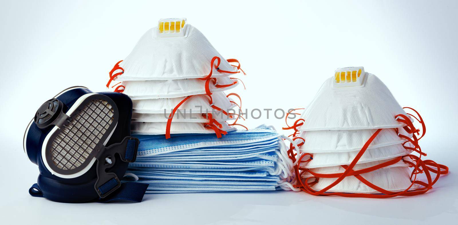 Stack of medical masks with respirator isolated on white background