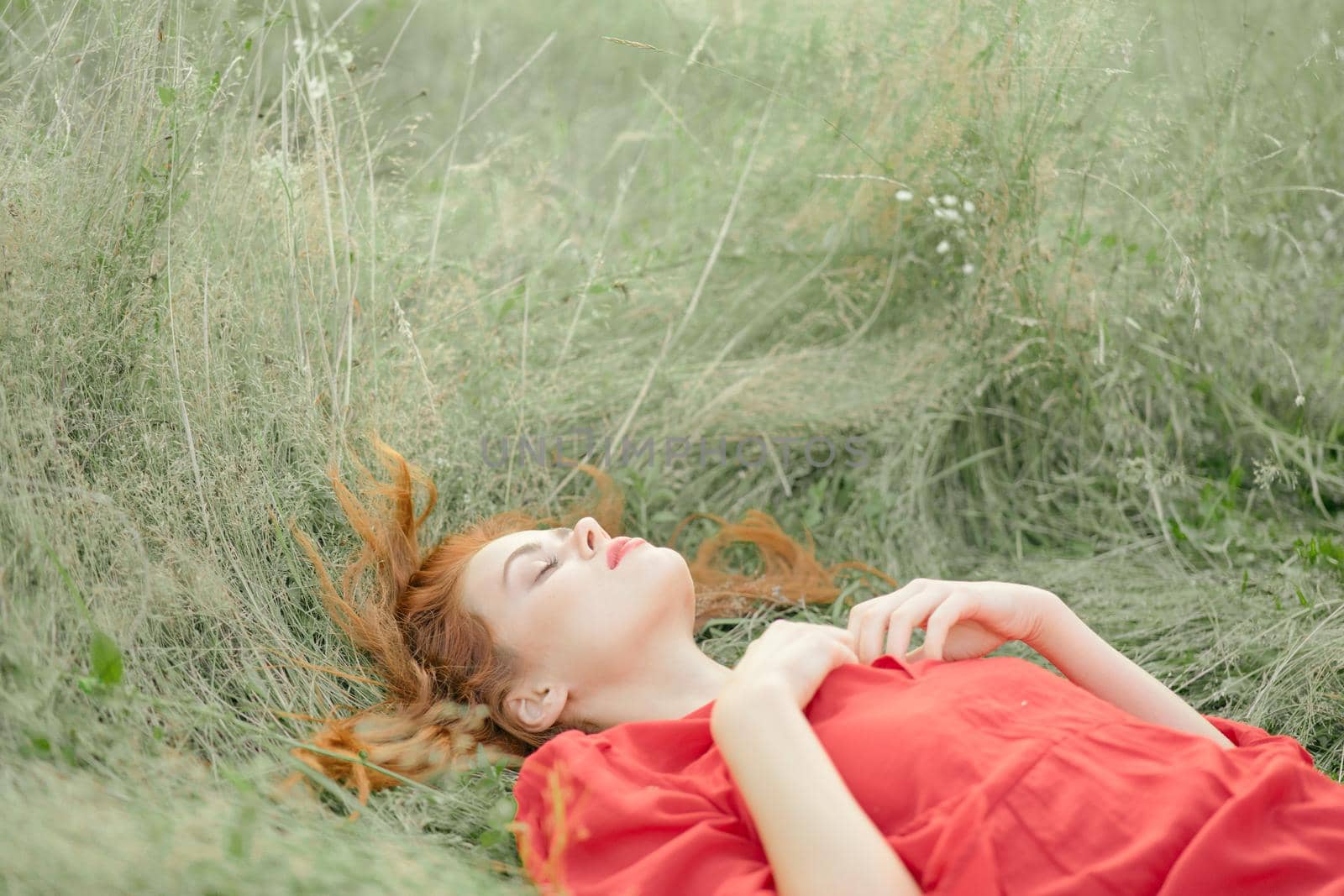 pretty woman in red dress lies on the grass in the field nature fresh air by Vichizh
