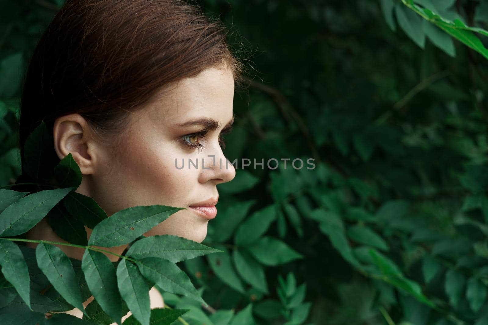 portrait of a woman skin care bare shoulders green leaves nature model. High quality photo
