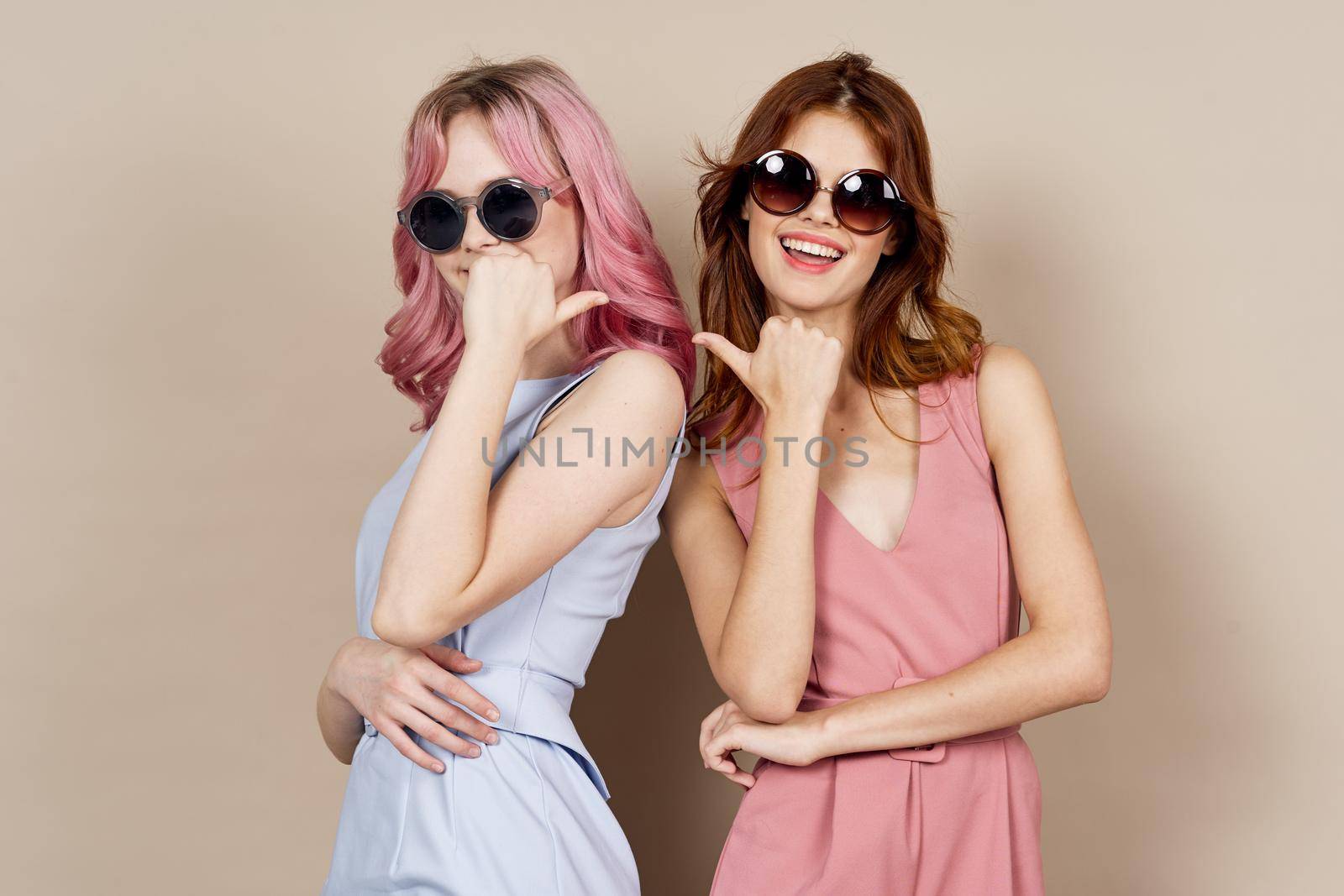 two girlfriends stand side by side fashion clothing glamor posing. High quality photo
