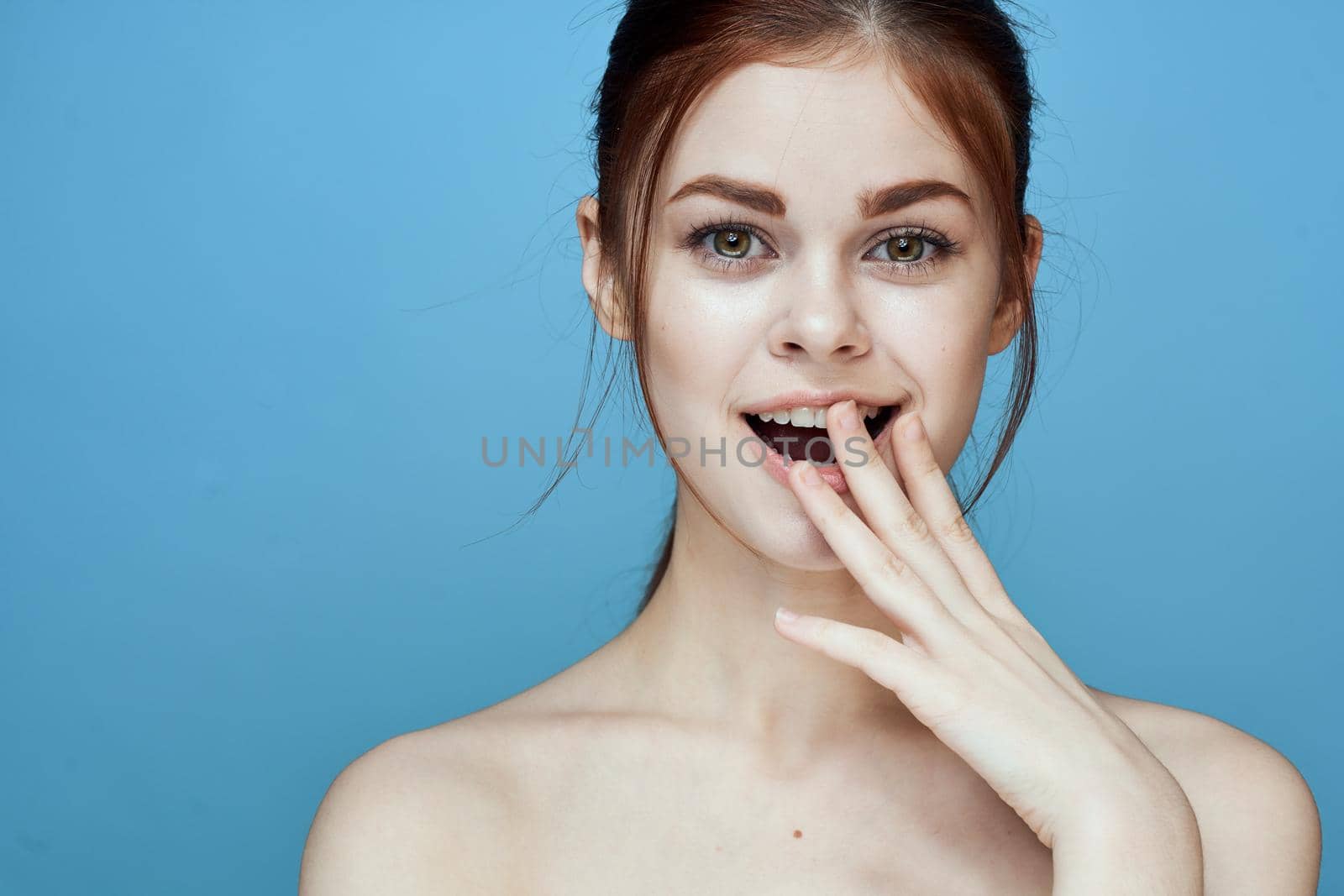 woman with bared shoulders pigtail emotions posing blue background. High quality photo