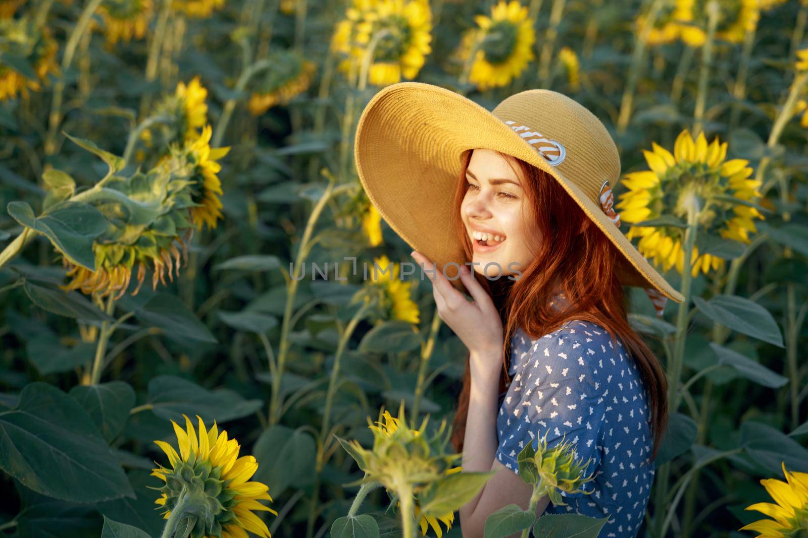pretty woman with hat in the field of sunflowers freedom nature. High quality photo