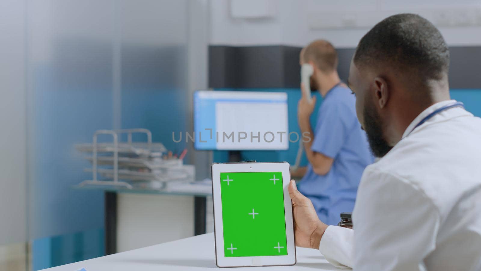 African american therapist doctor looking at mock up green screen chroma key tablet computer with isolated display monitoring sickness development working at healthcare treatment. Medicine concept