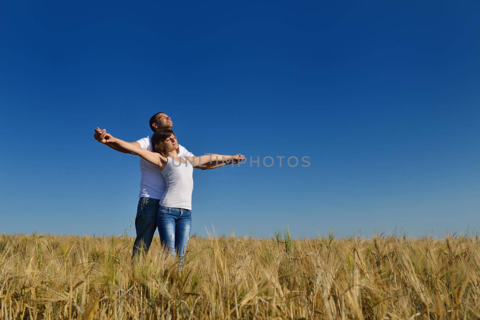 happy young couple in love have romance and fun at wheat field in summer