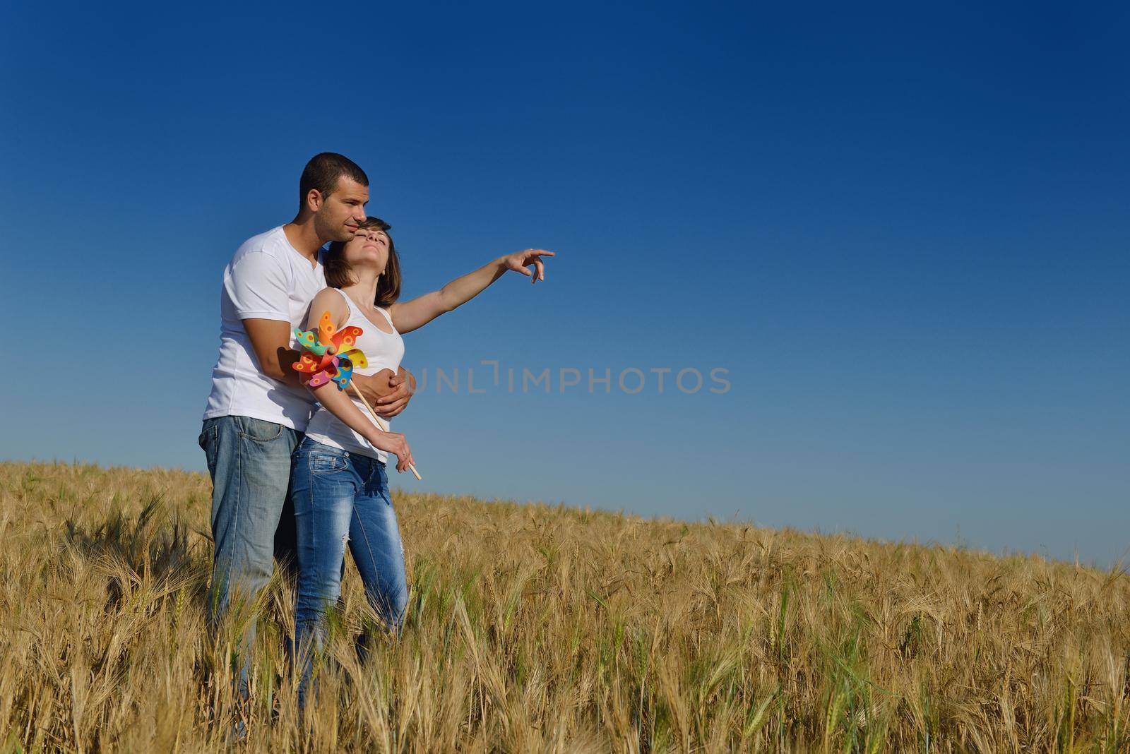 happy young couple in love have romance and fun at wheat field in summer