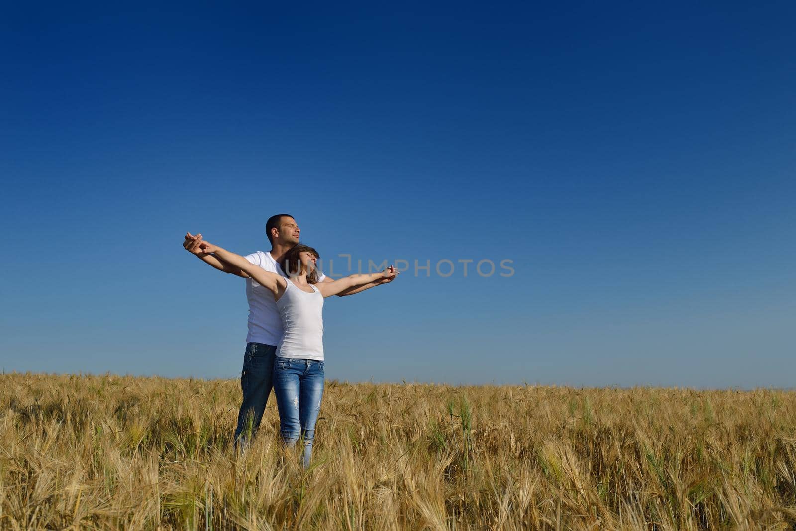 happy young couple in love have romance and fun at wheat field in summer