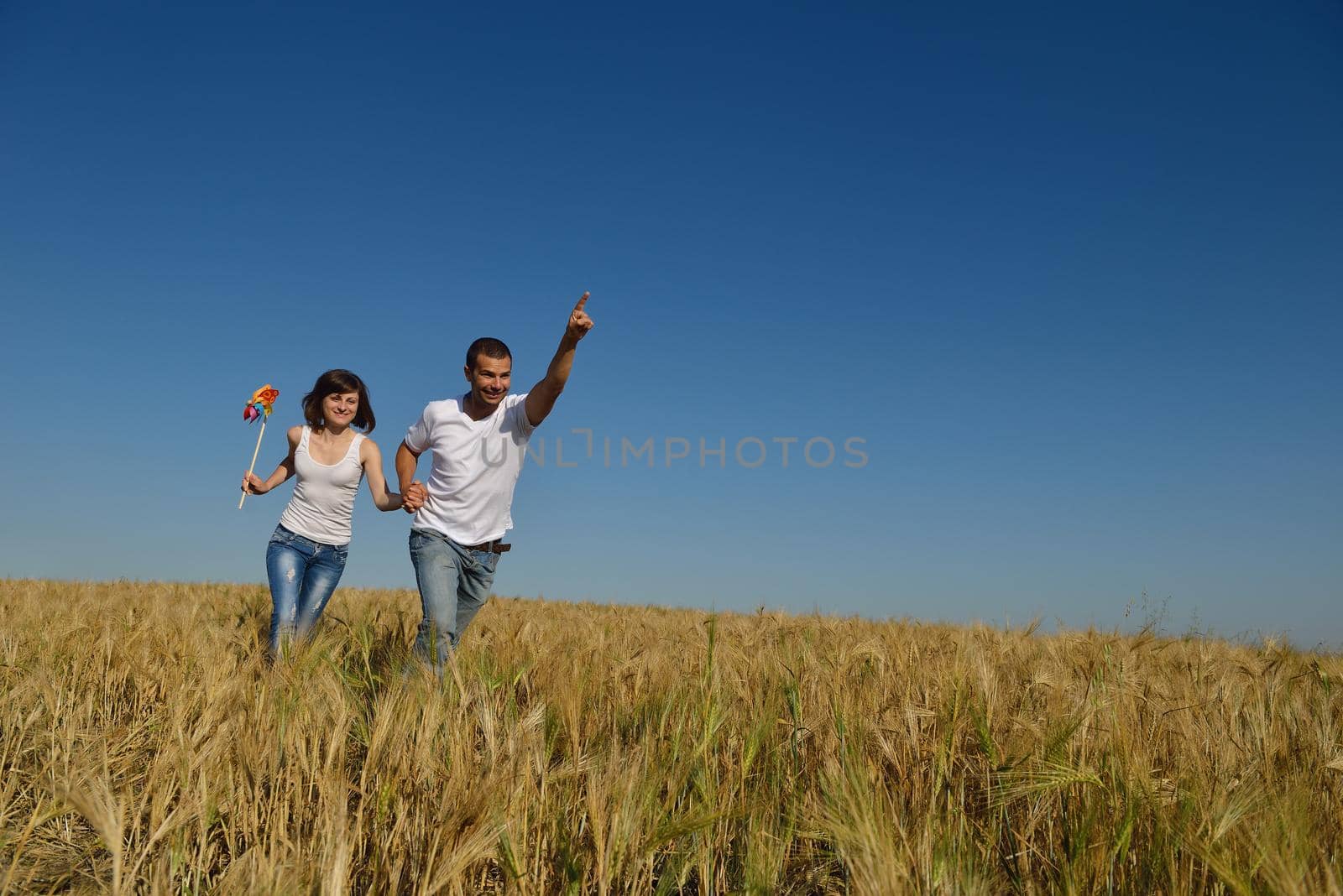 happy couple in wheat field by dotshock