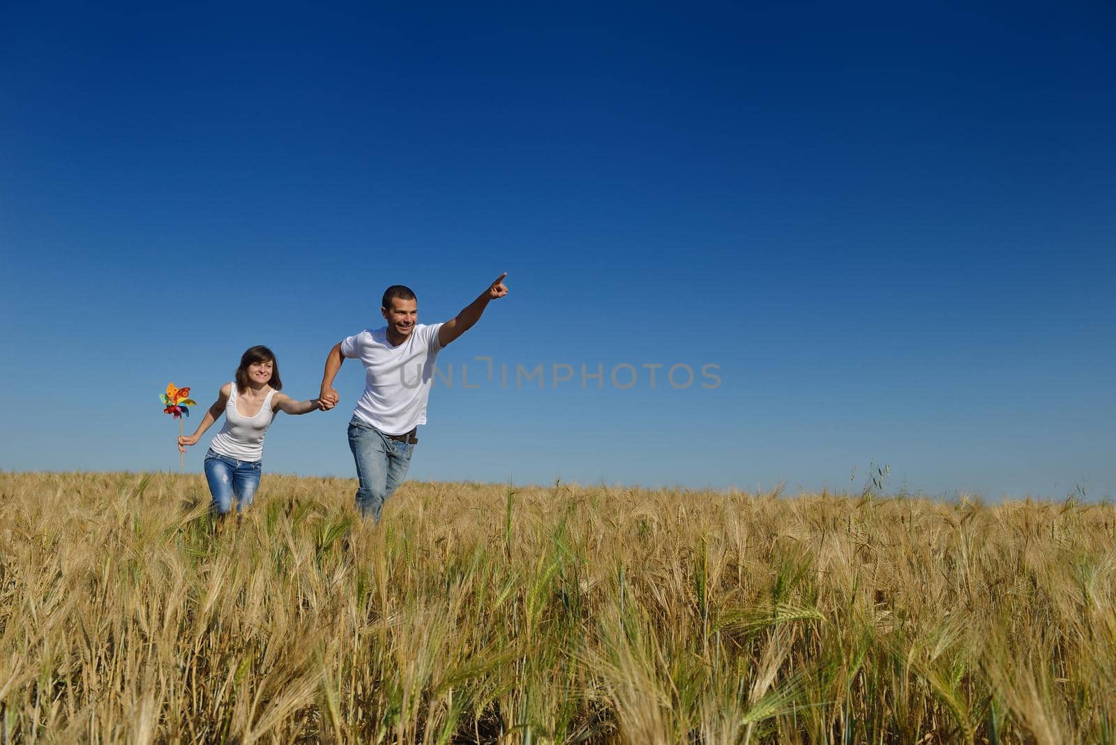 happy young couple in love have romance and fun at wheat field in summer