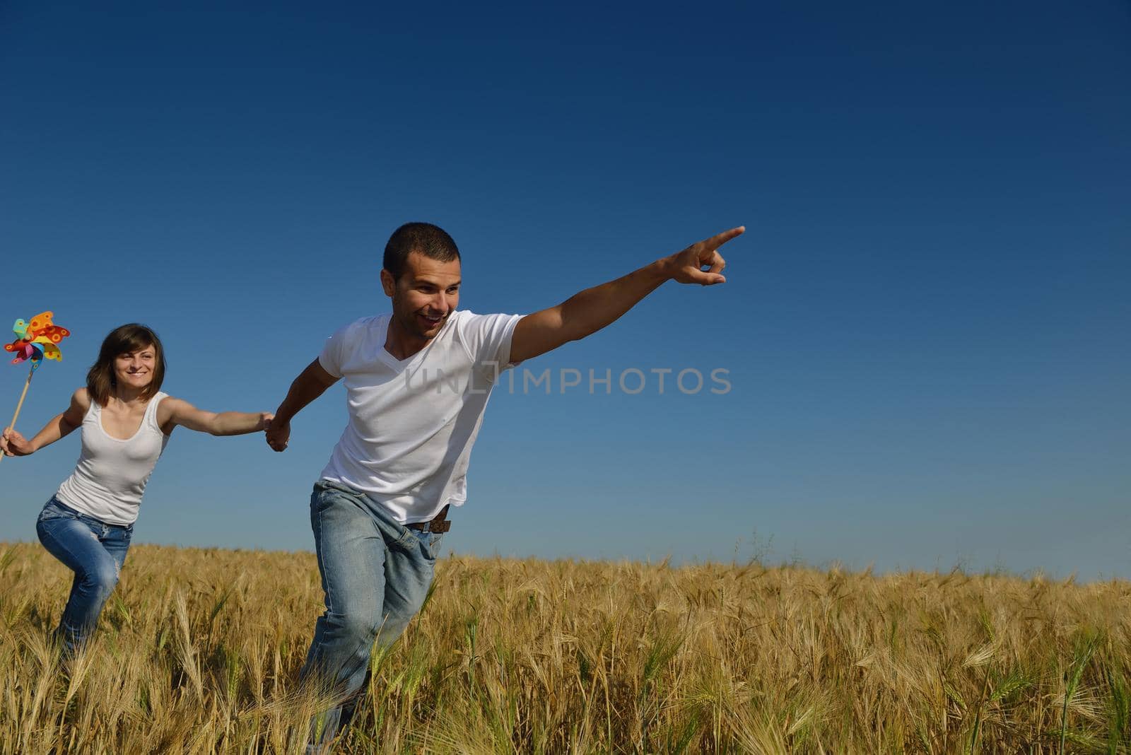 happy couple in wheat field by dotshock