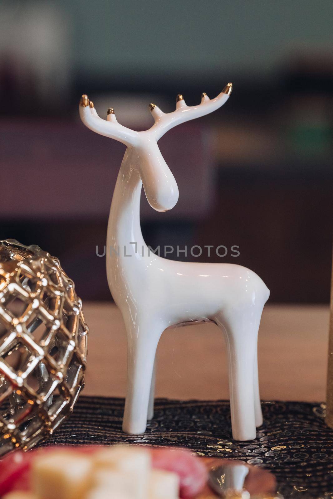 White deer figurine on the festive table by StudioLucky