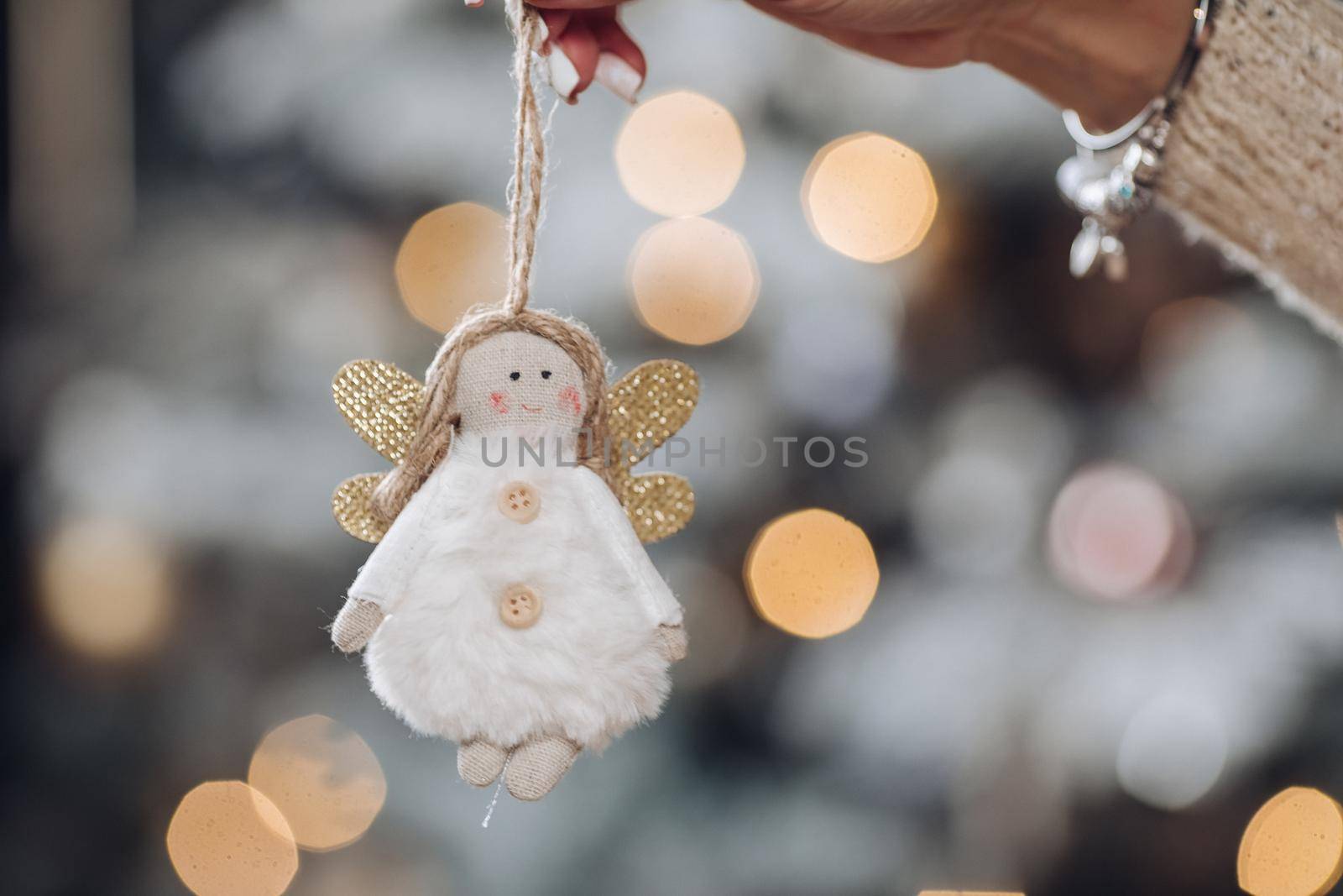 Woman hand is holding Christmas tree decoration by StudioLucky