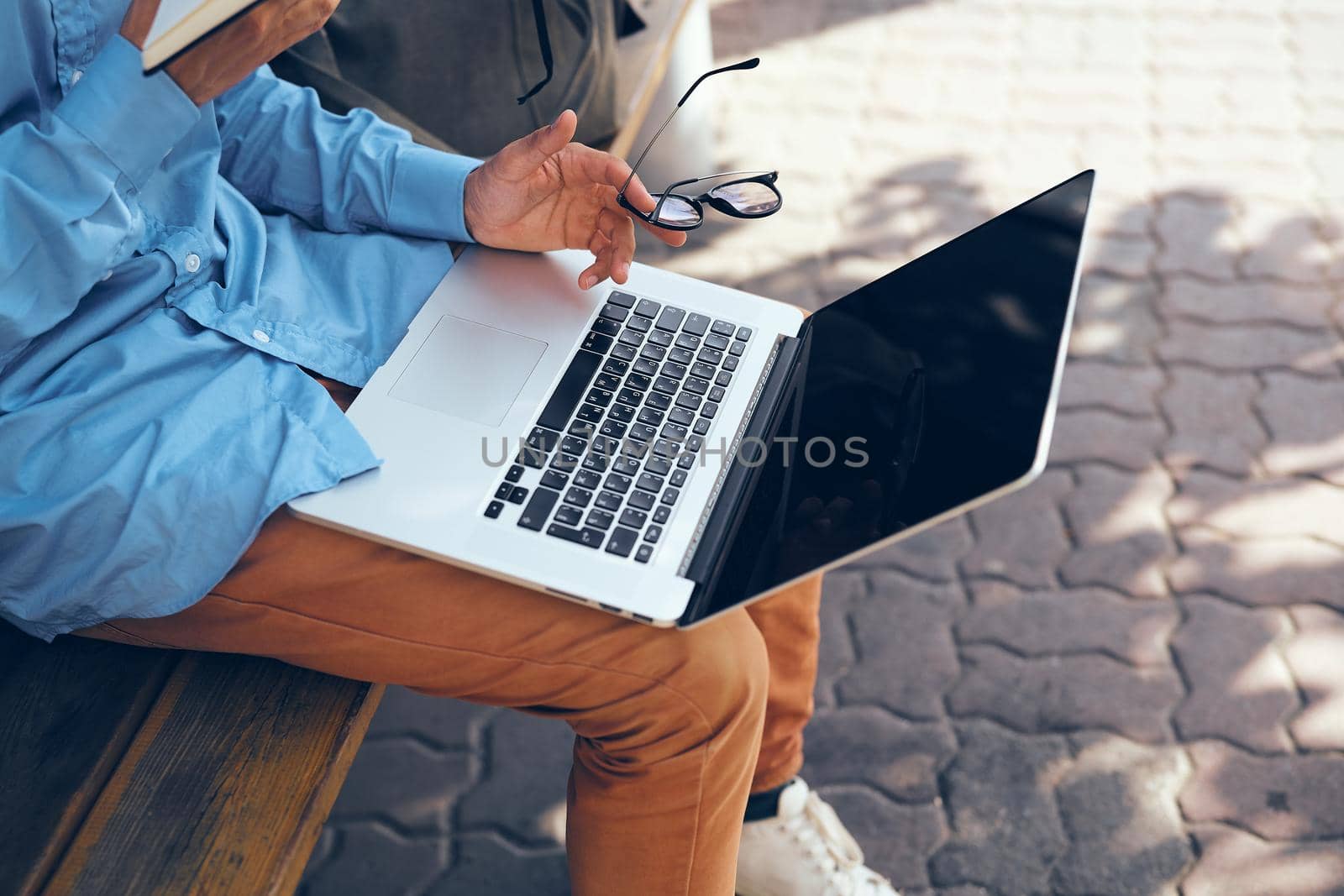 man with laptop outdoors in the park. High quality photo