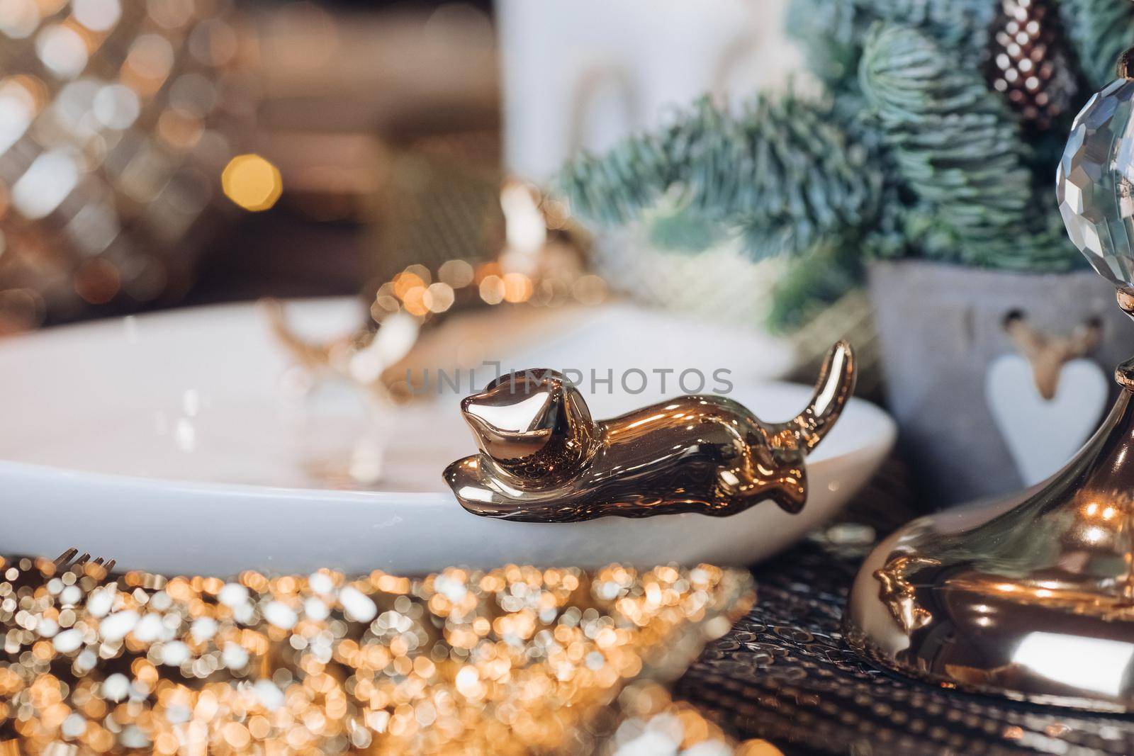 Close up of white plate decorated with a golden figurine by StudioLucky