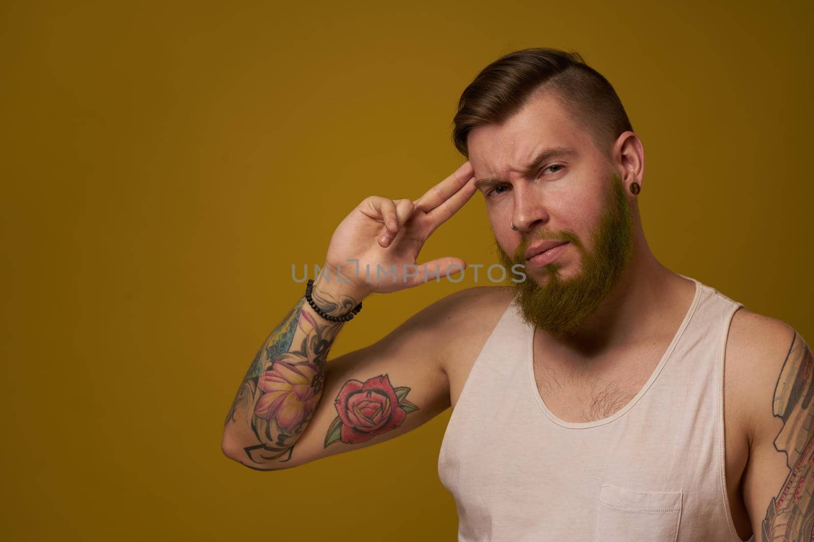 macho man in white t-shirt tattoos on his arms posing isolated background. High quality photo