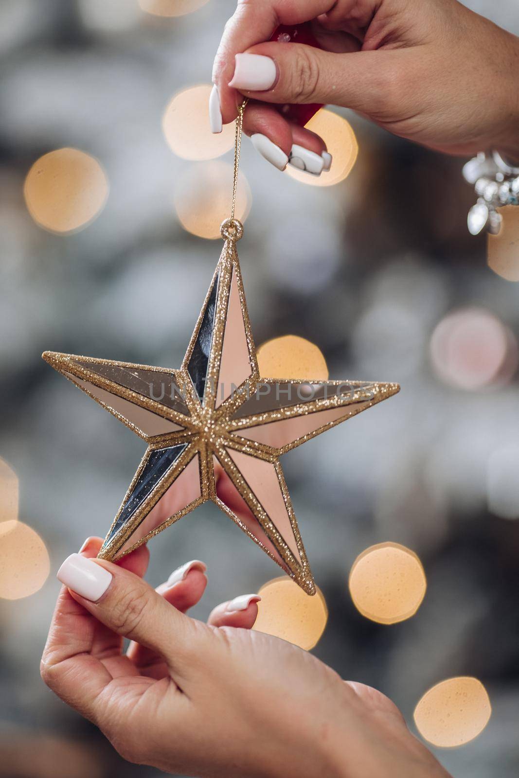 Close up of woman with toy glass decorative star in hands. New Year eve concept