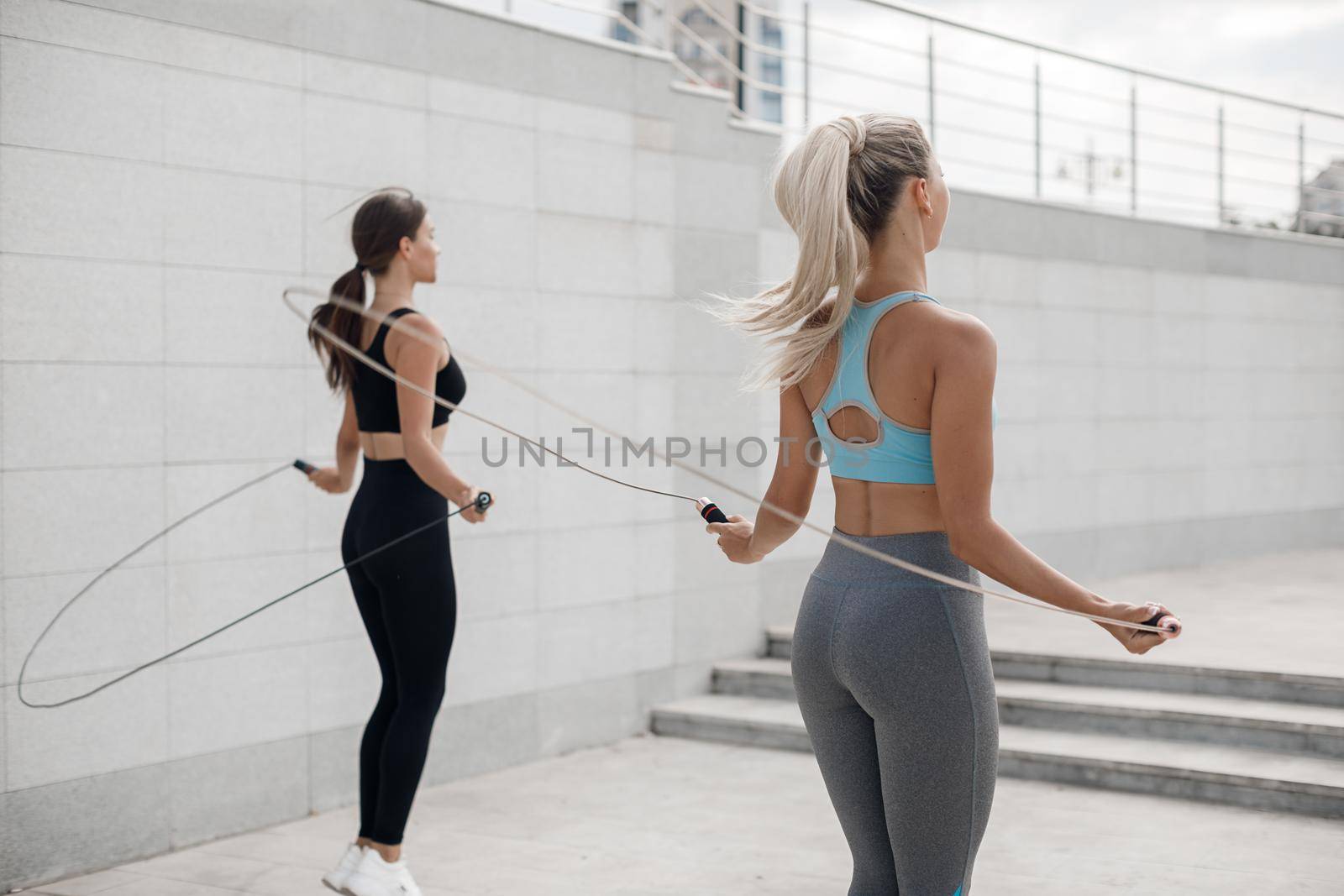 Two women doing fitness outdoor by splash