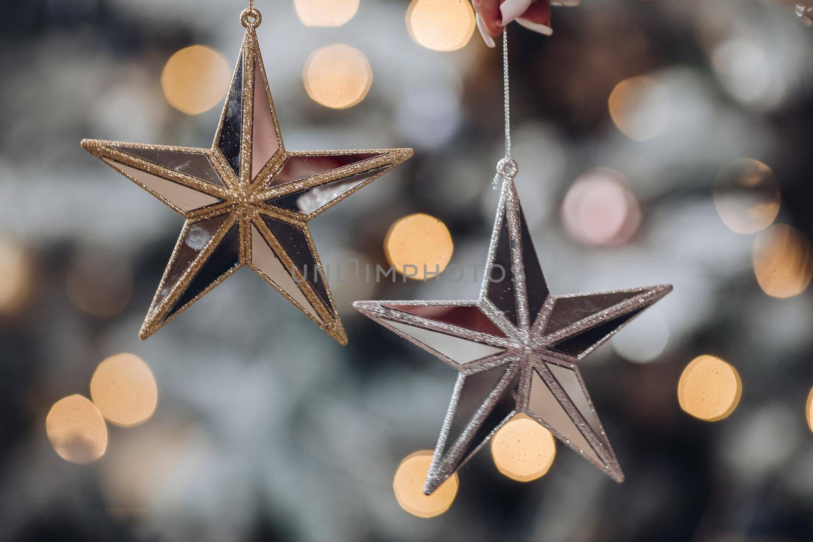 Close up of woman with toy glass decorative star in hands. New Year eve concept