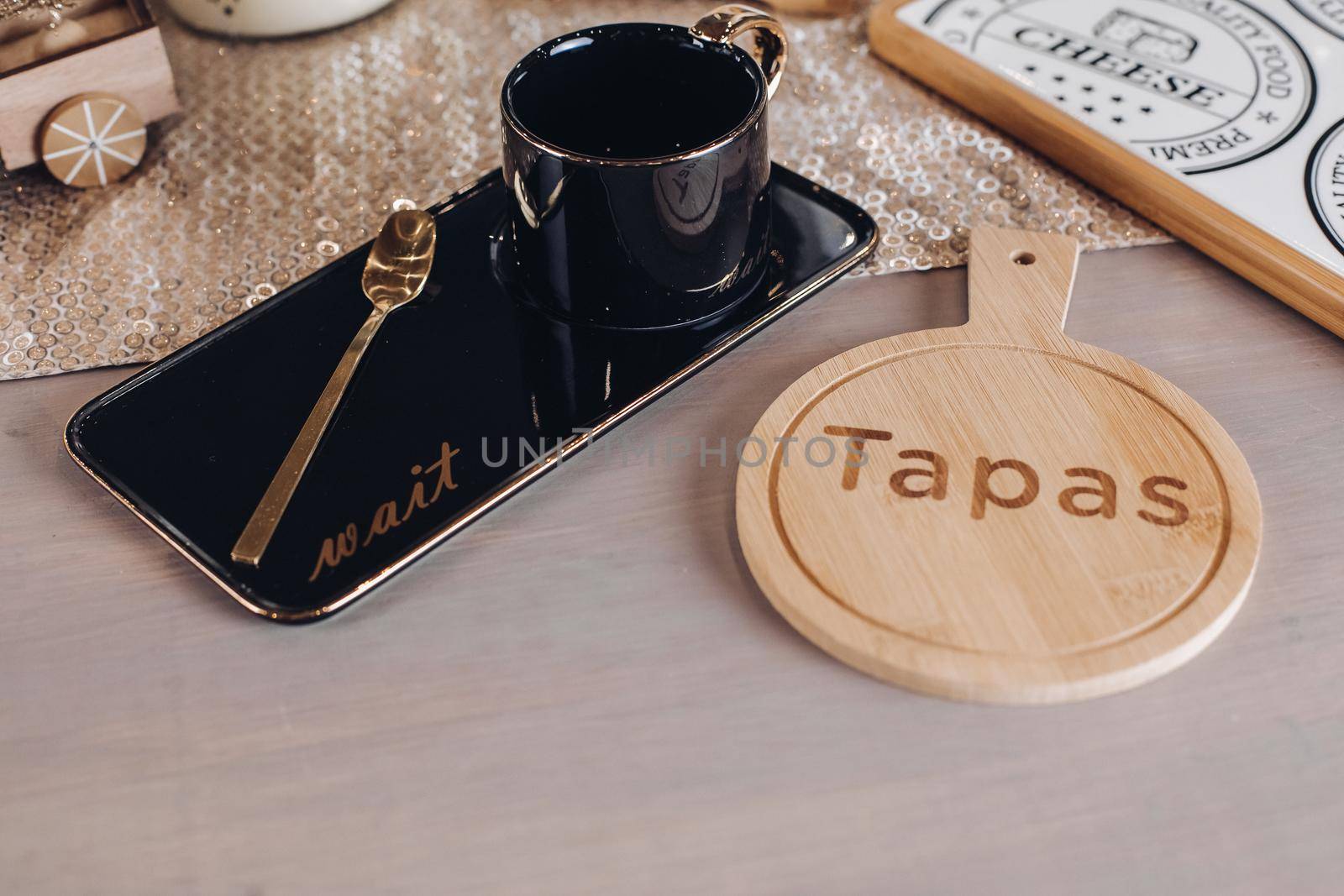 Top view of black coffee mug near wooden cutting board for cheese. Copy space
