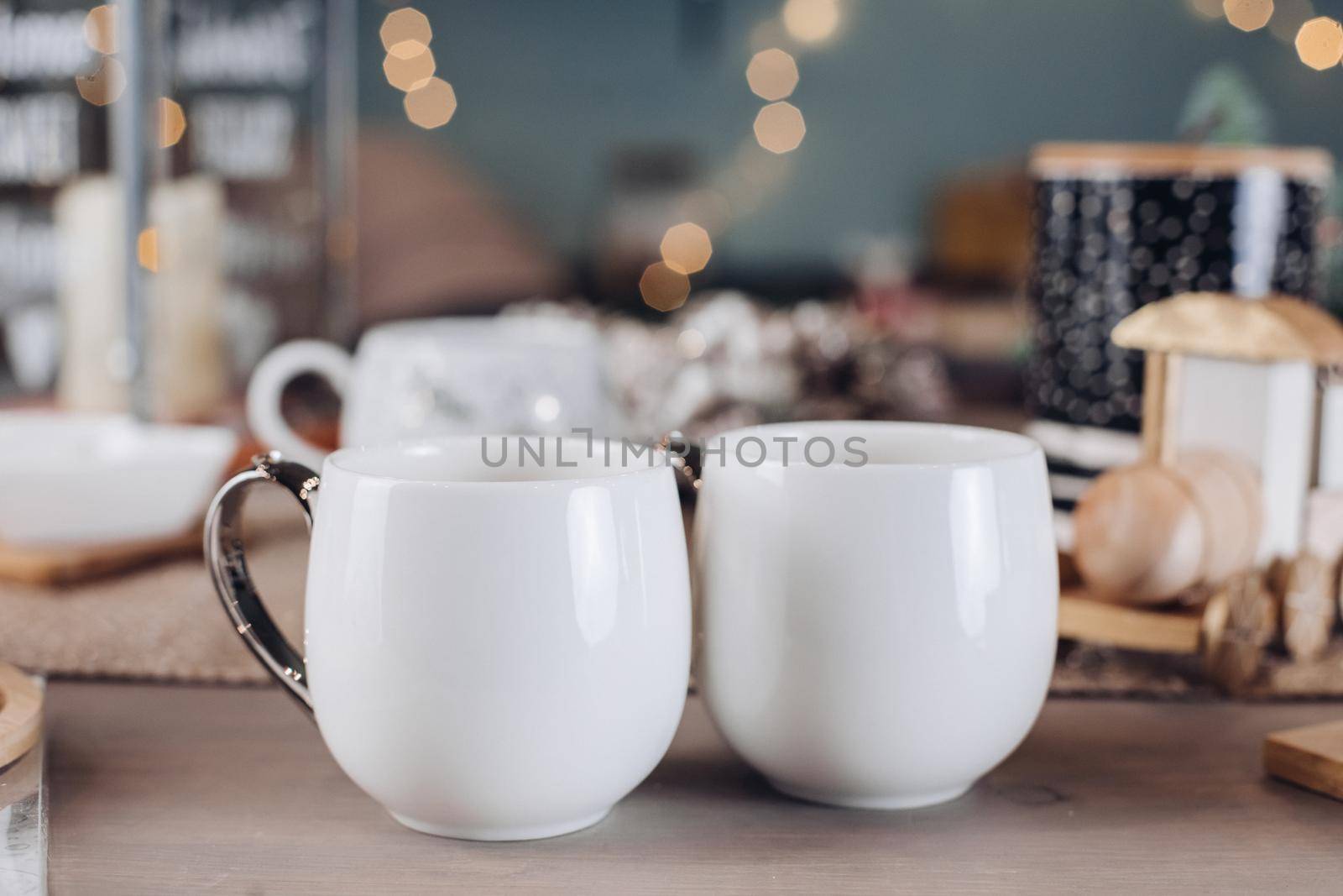 Two beautiful white cups on the festive table by StudioLucky