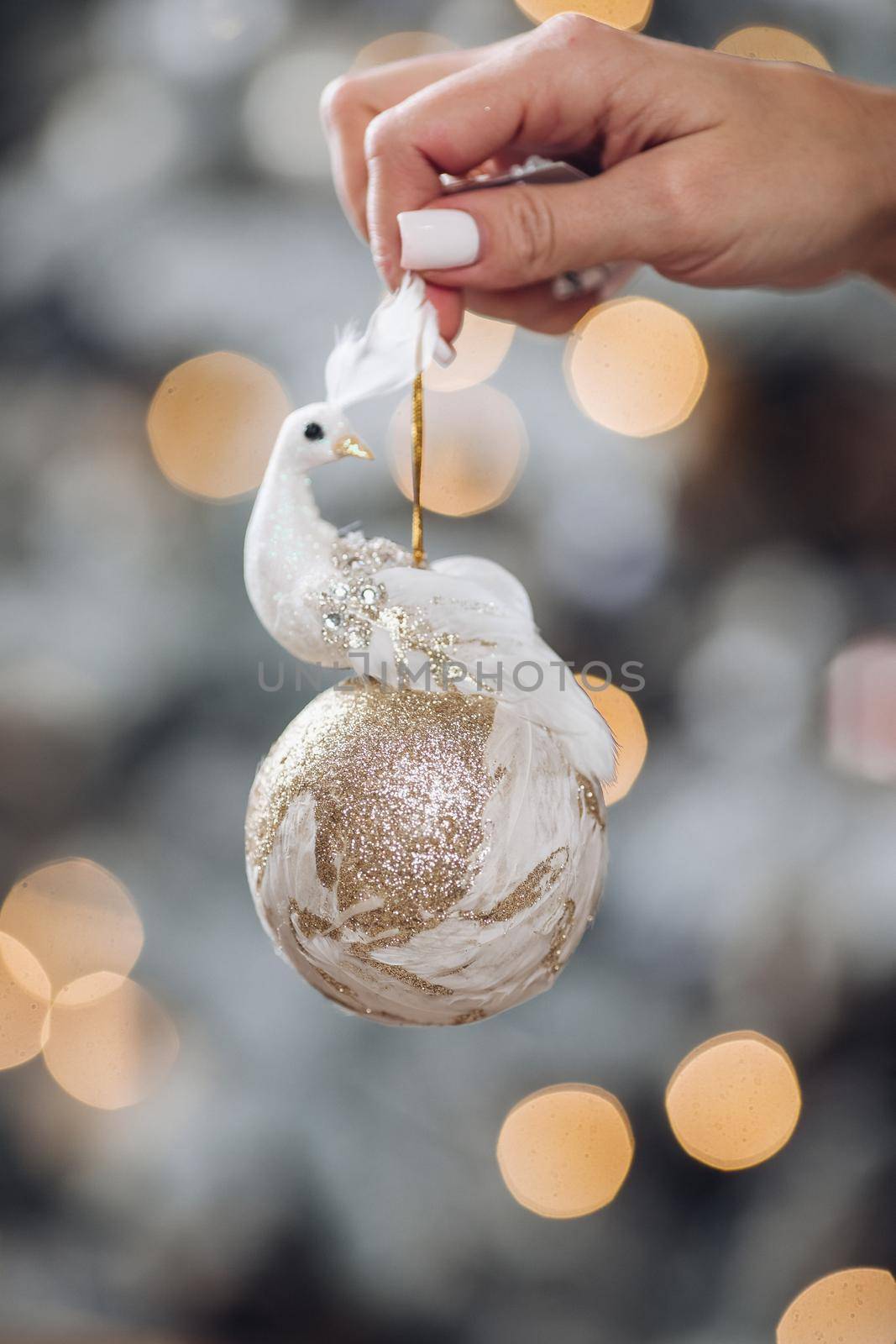 Woman hand is holding Christmas tree decoration by StudioLucky