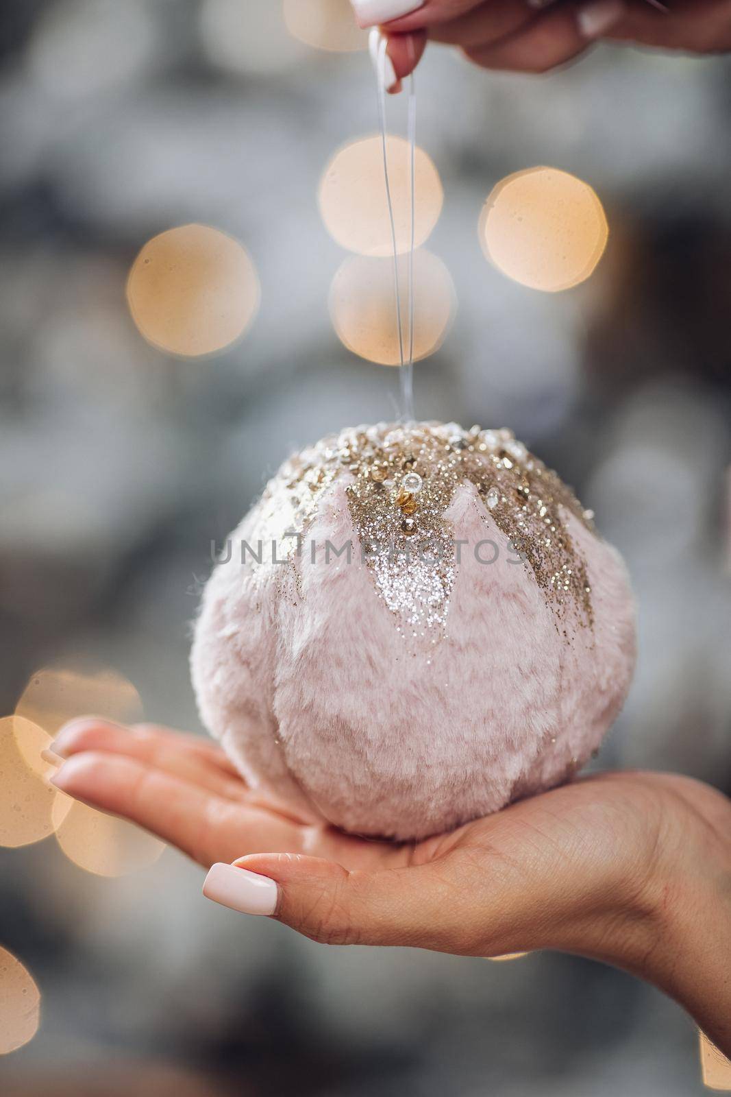 Woman hand is holding Christmas tree decoration by StudioLucky