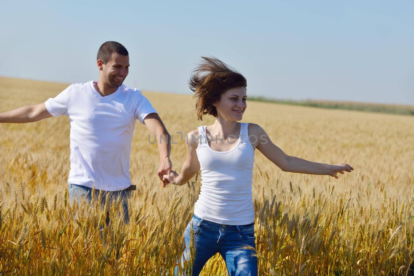 happy young couple in love have romance and fun at wheat field in summer