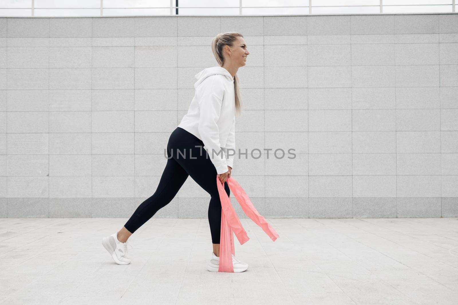 Young woman doing fitness outdoor by splash