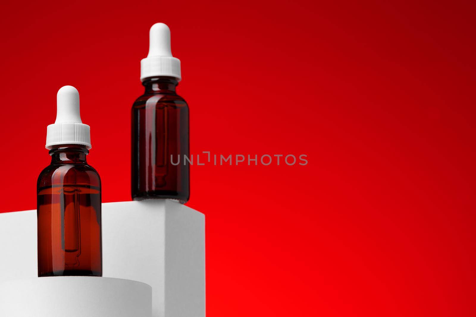 Beauty oil bottle with pipette against red background close up